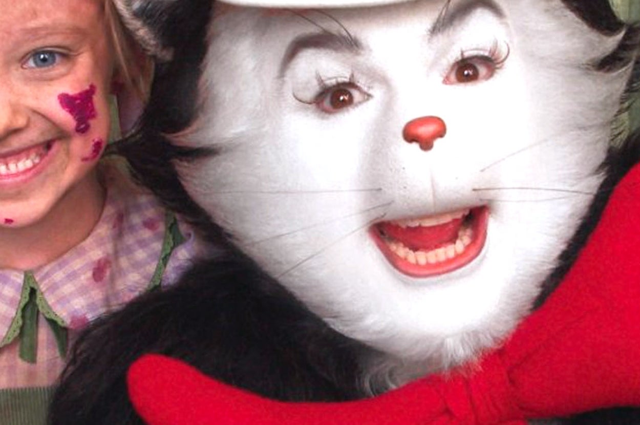 Child in costume with painted face stands next to a person dressed as the Cat in the Hat, featuring a large bow tie and signature striped hat