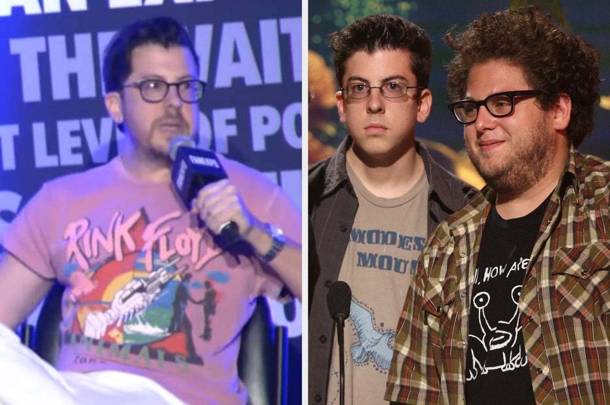 Two men in casual clothing at an event; one wears a Pink Floyd T-shirt, the other wears layered shirts with graphic designs