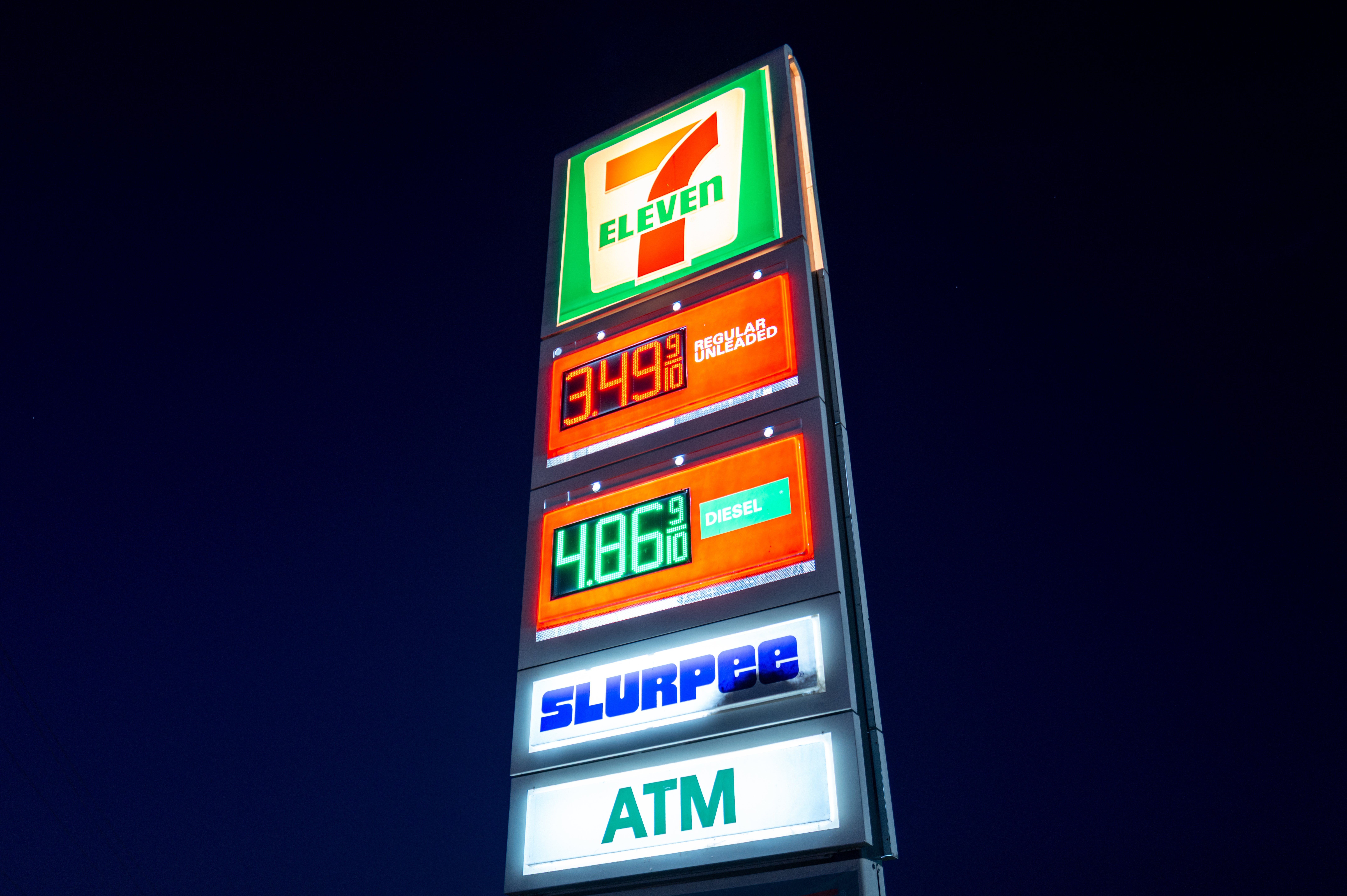 7-Eleven-skilt som viser drivstoffpriser: $3,49 for vanlig gass, $4,86 for diesel, med Slurpee- og minibanktjenester annonsert