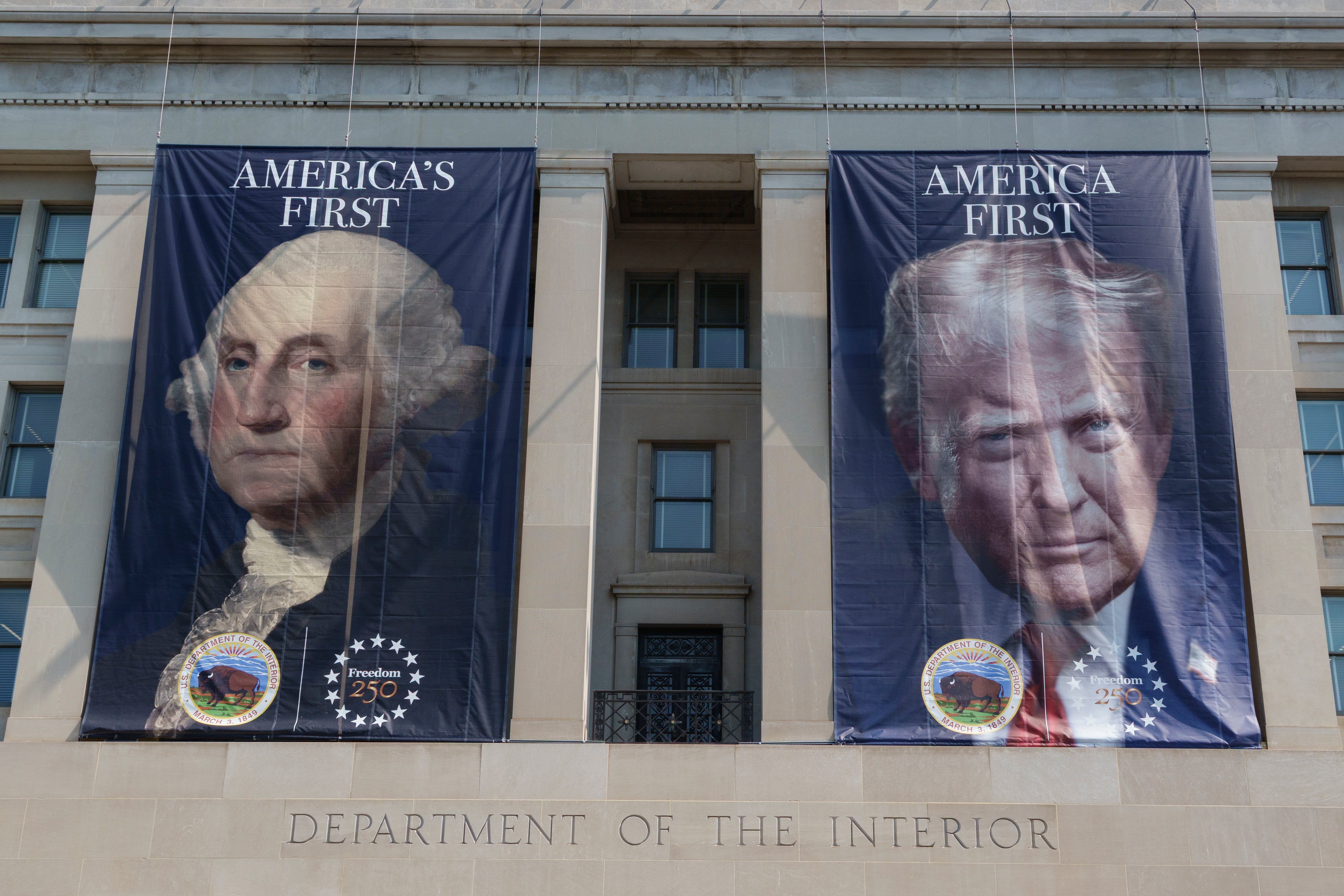 Bannere på innenriksdepartementet har portretter av George Washington og en moderne politisk skikkelse, med teksten