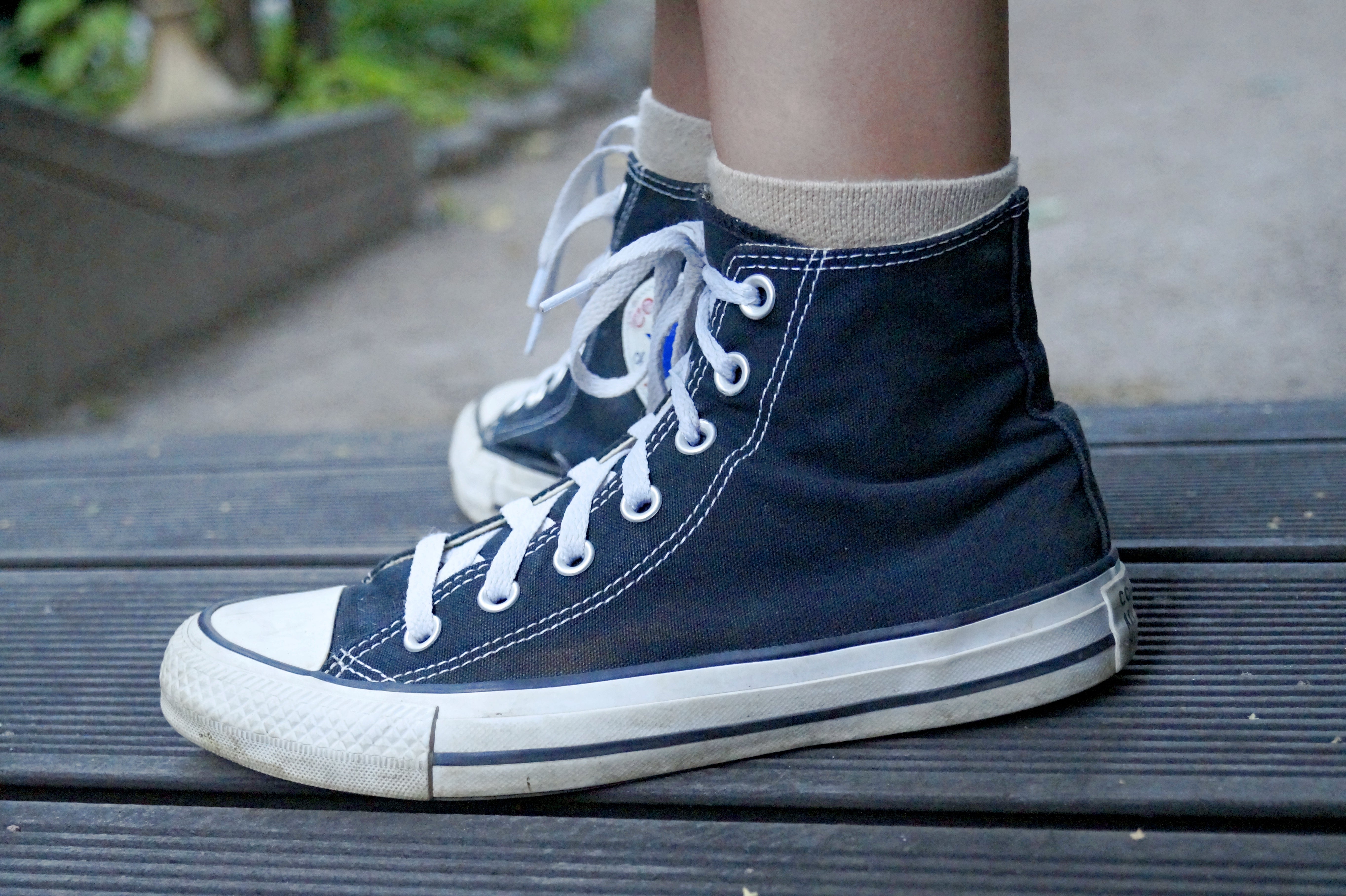 A person wearing black Converse