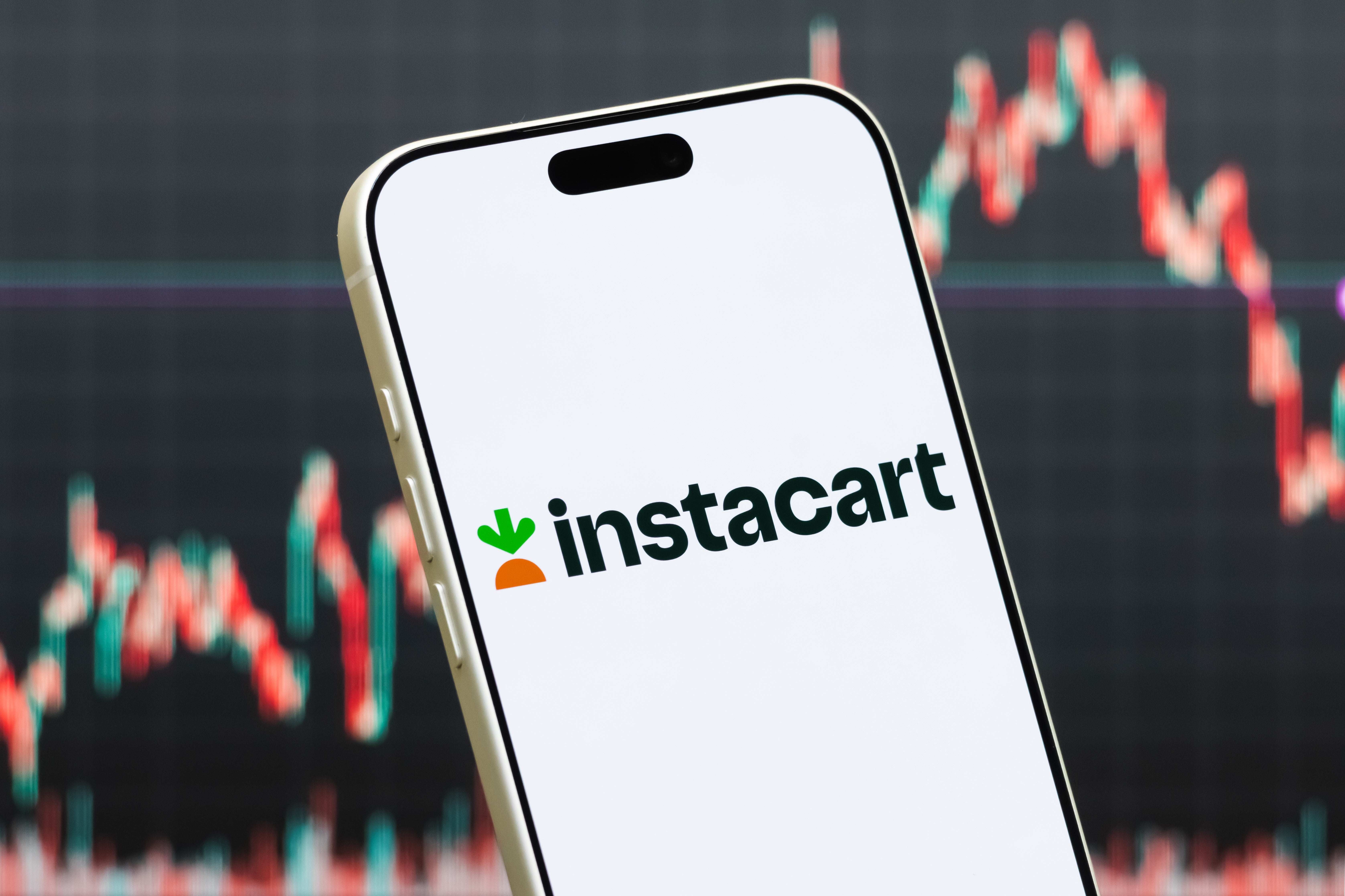 Smartphone displaying Instacart logo with banal marketplace graph successful background, suggesting concern oregon fiscal context