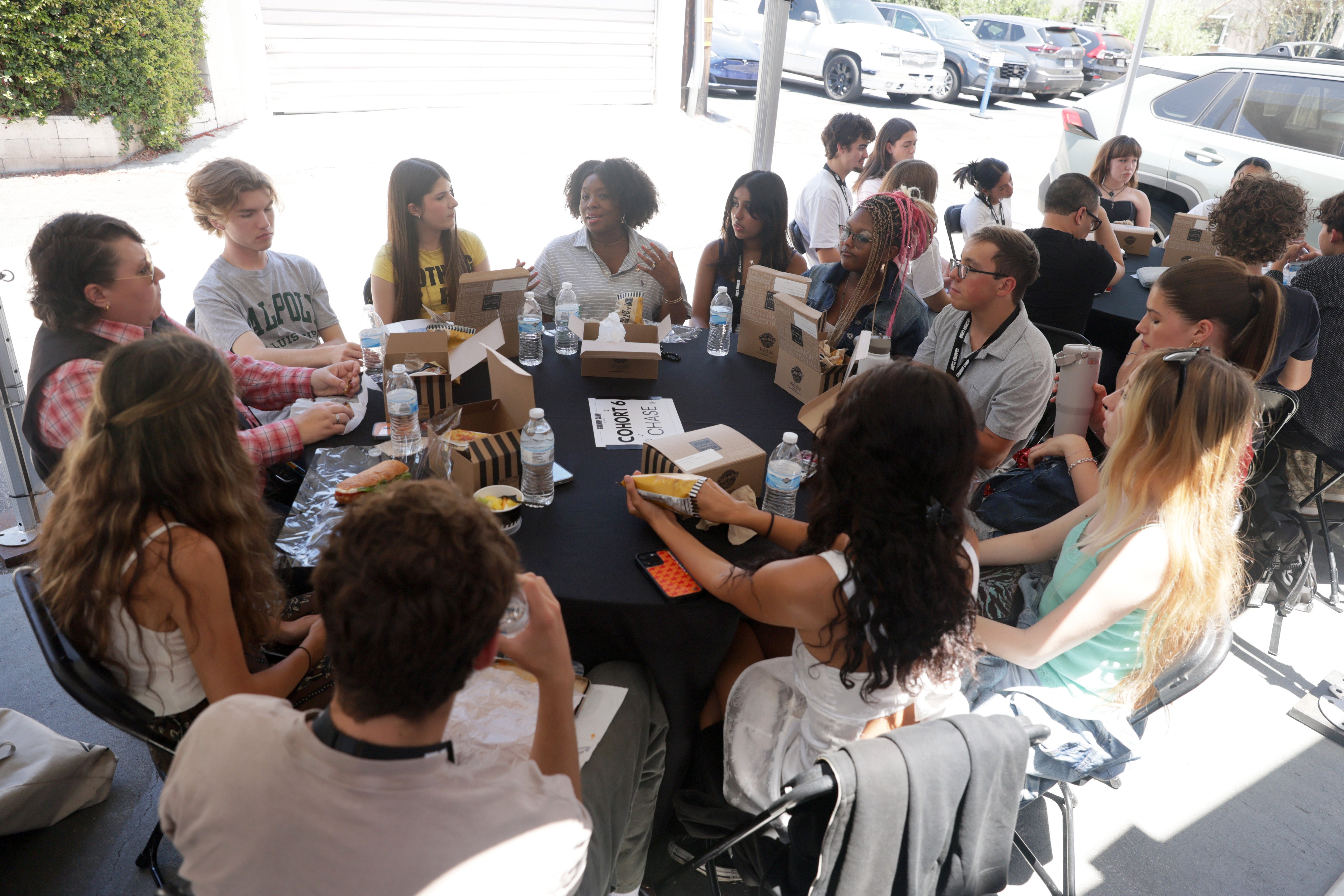 People sitting astir a ample array outdoors, enjoying a repast and engaging successful conversation