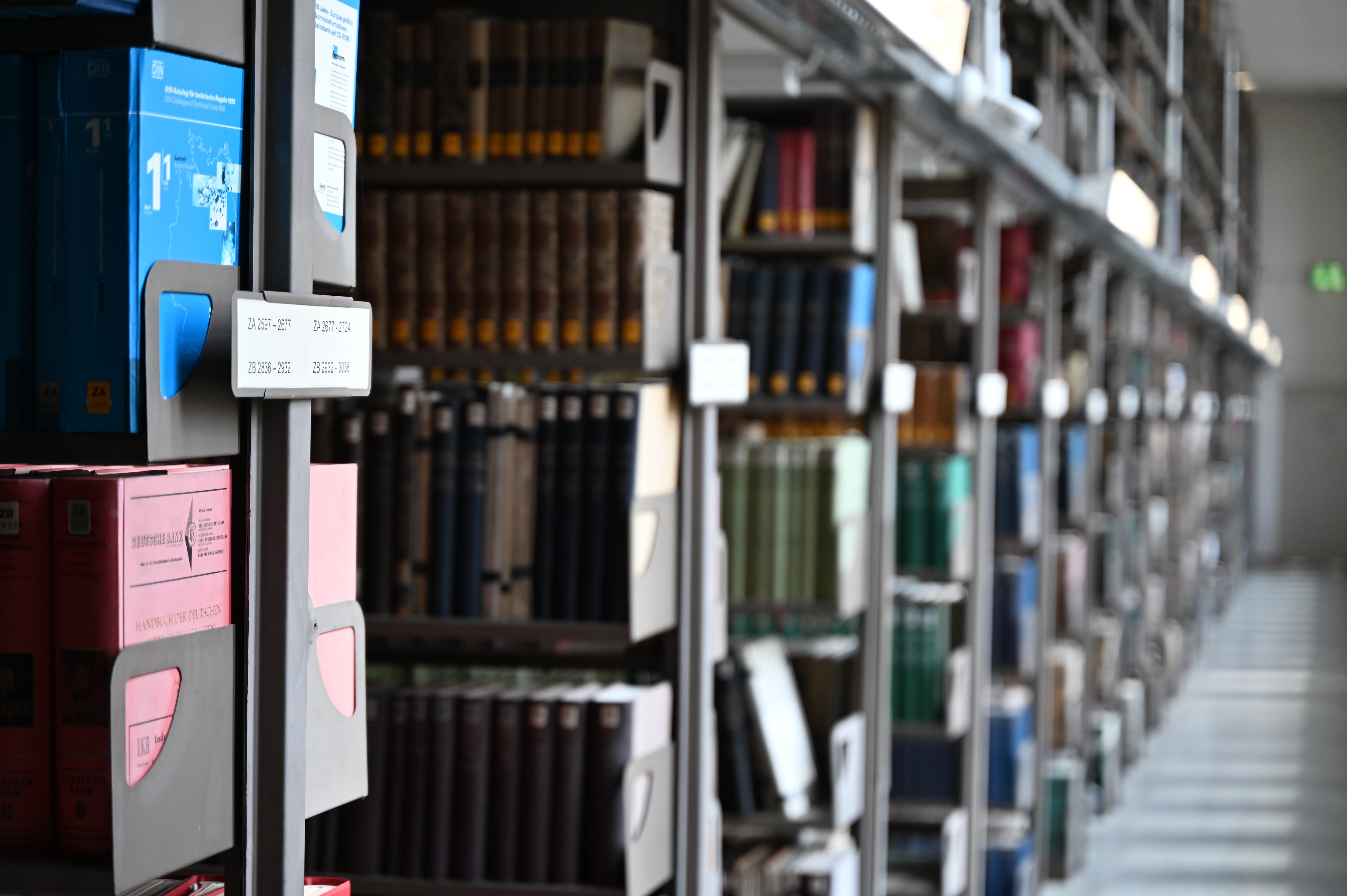 Library shelves filled with assorted books and documents, neatly organized and extending into the distance