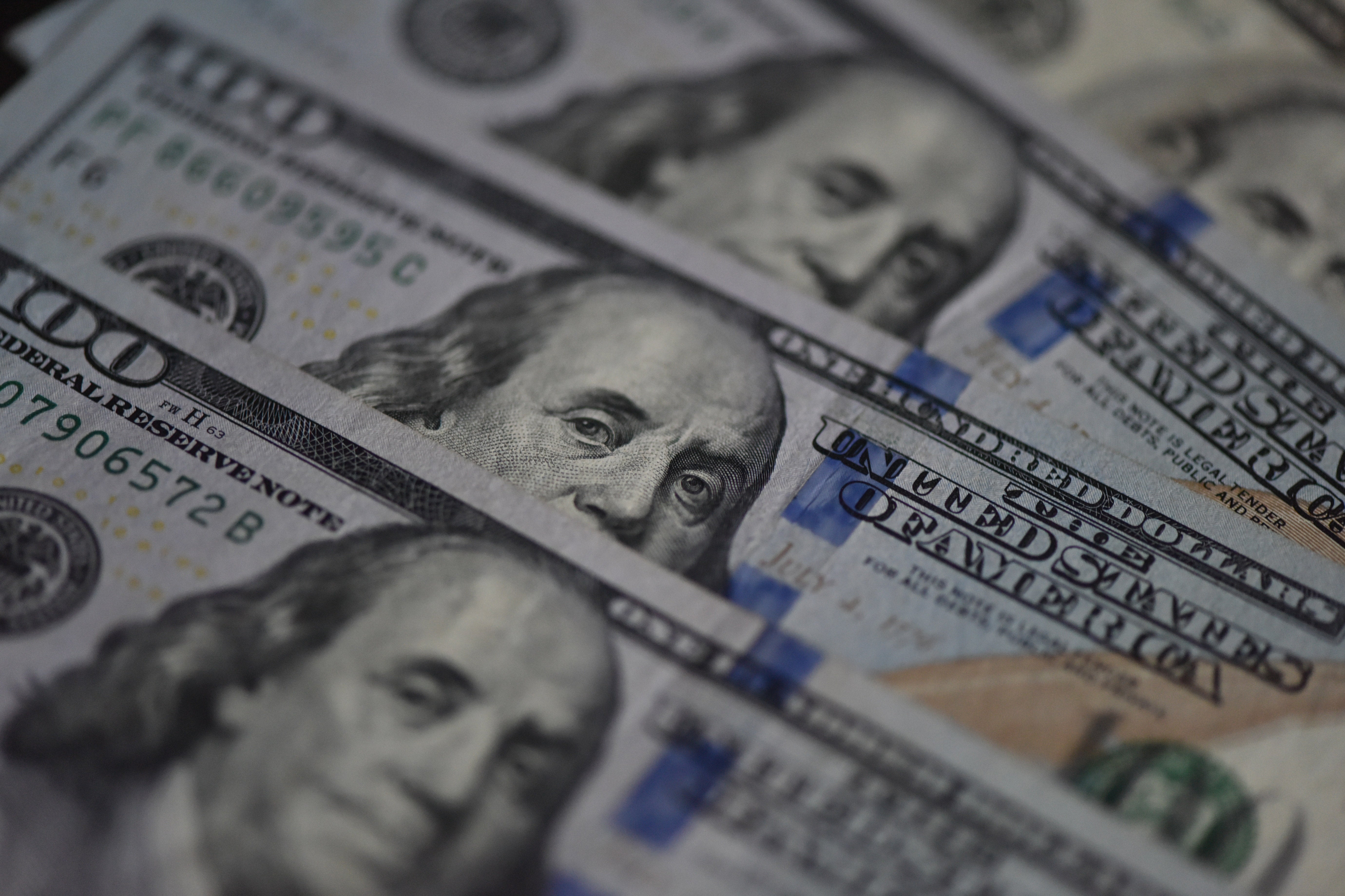 Several U.S. 1 100 dollar bills featuring Benjamin Franklin's face