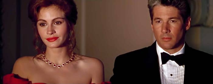 Julia Roberts, in an elegant off-shoulder gown with a necklace, stands beside Richard Gere in a tuxedo