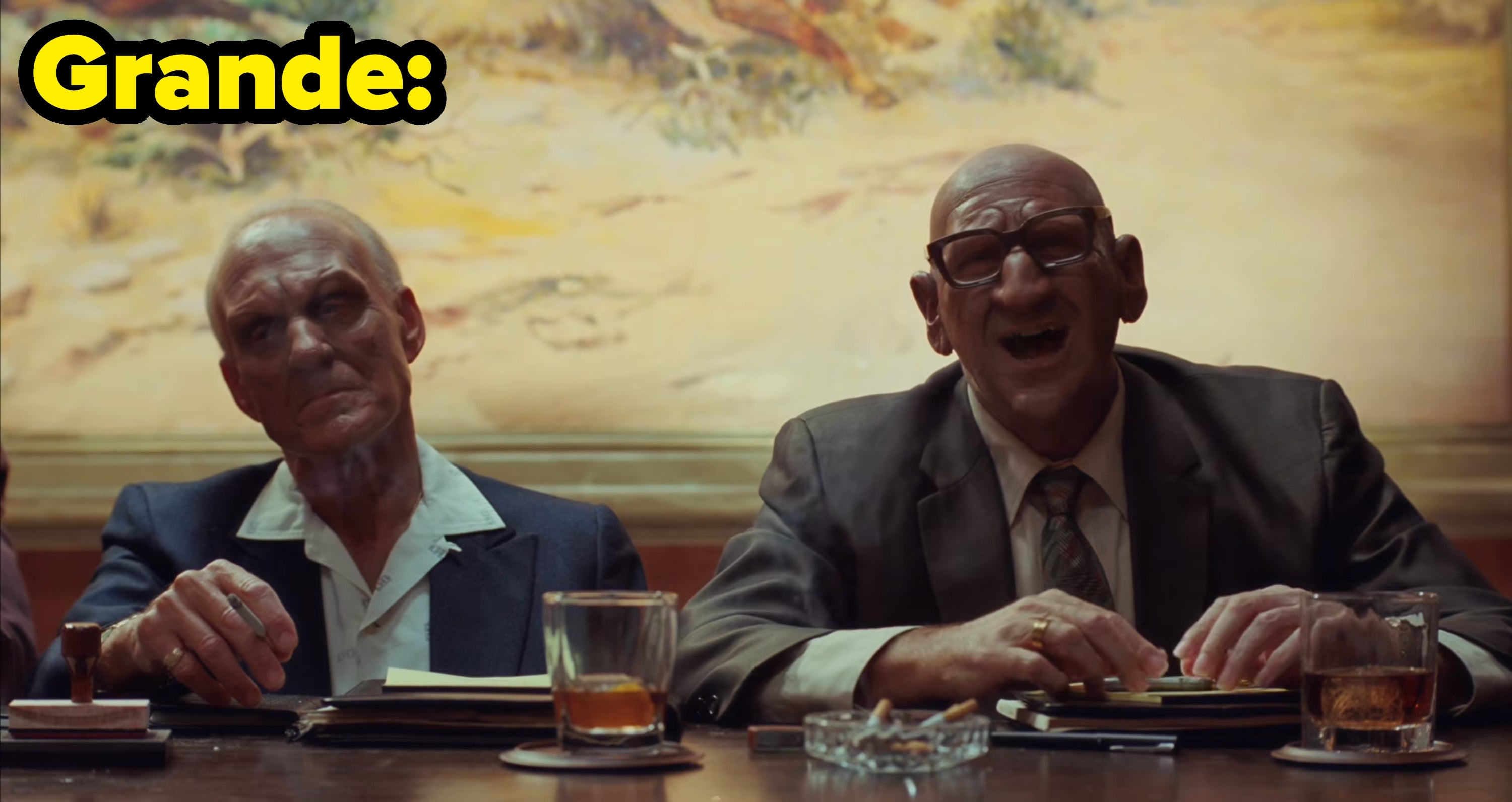 Grande's video, where two older men in suits sit at a table
