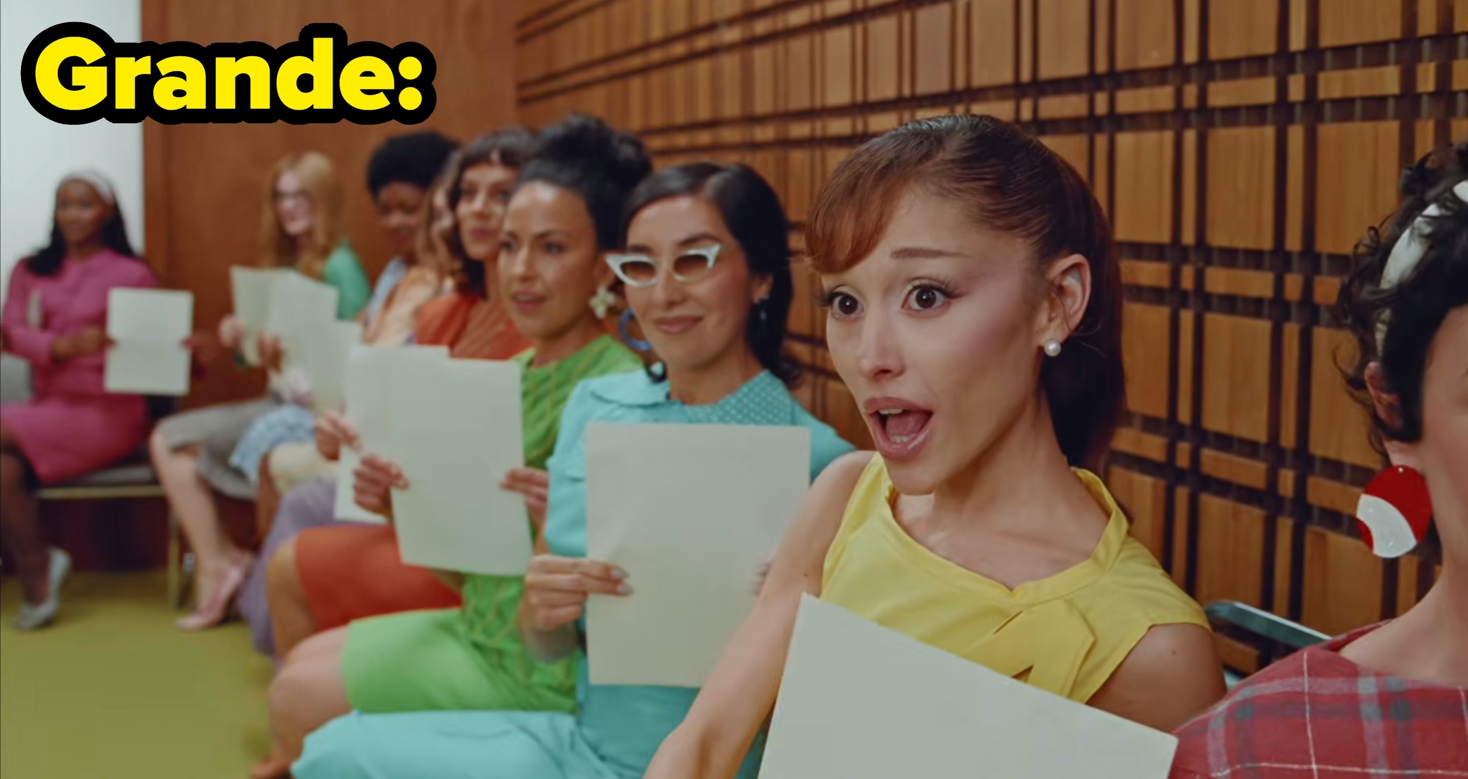 Grande's video, with women holding papers sitting in a row