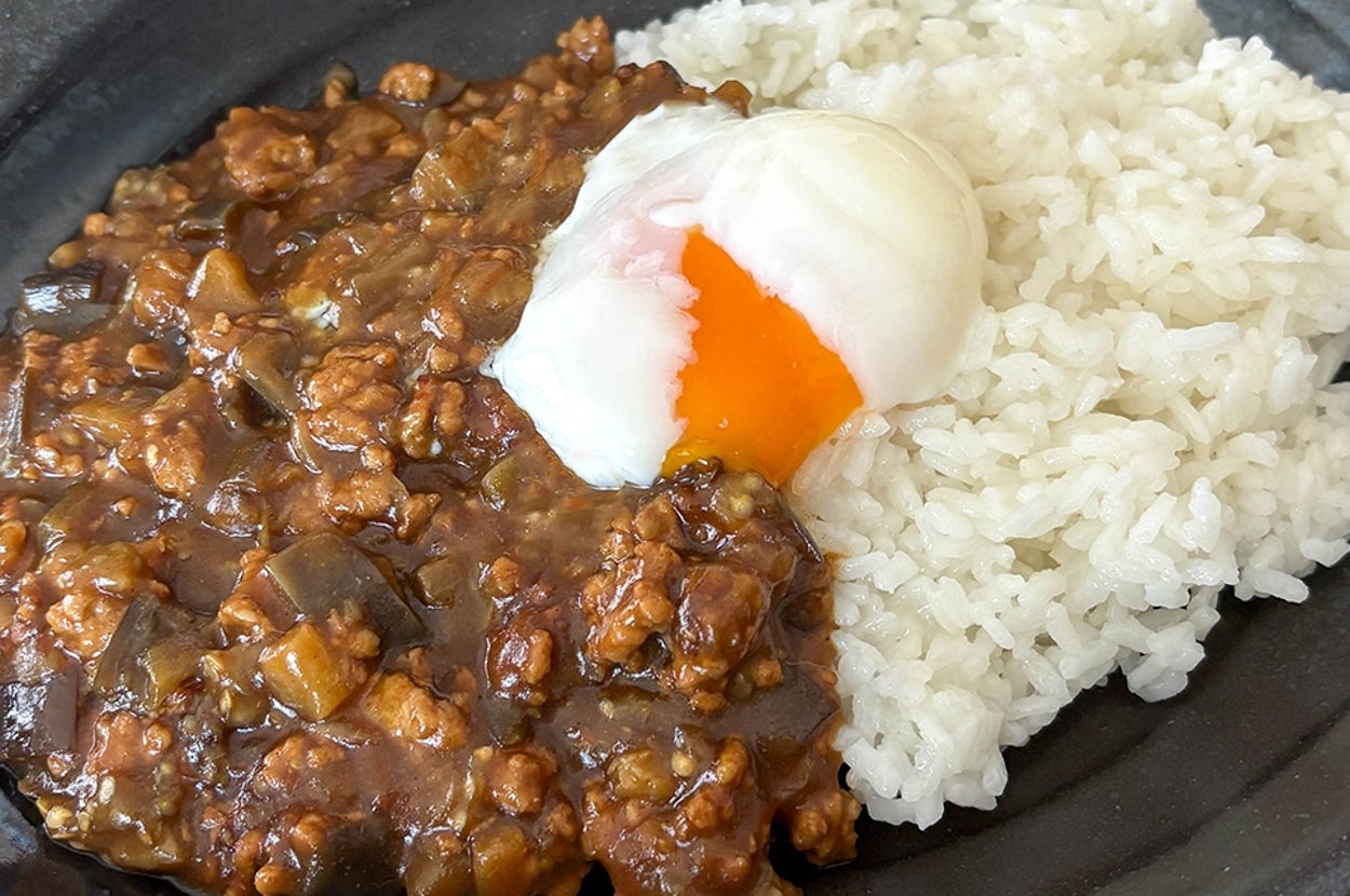 なすのキーマカレーに半熟卵がのった一皿。
