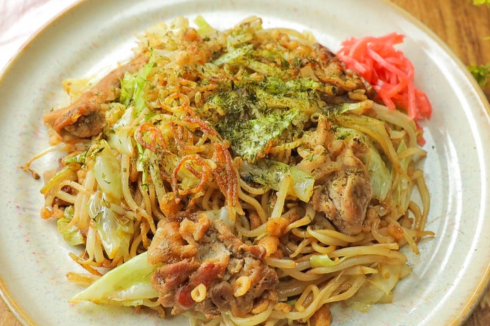 お皿に盛られた焼きそば。キャベツや豚肉が入り、上に青のりと紅しょうがが添えられている。