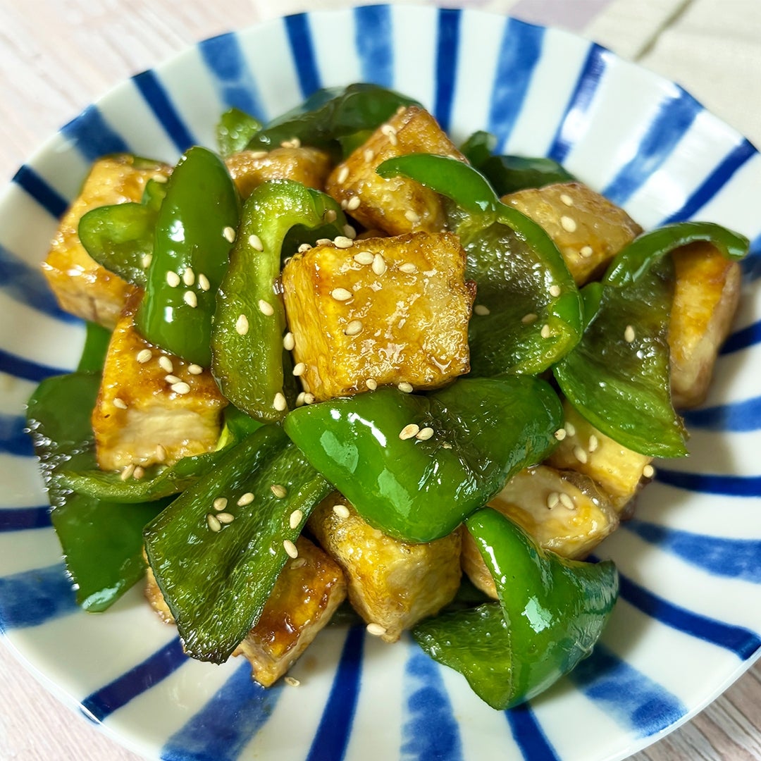 皿に盛られたピーマンと豆腐の甘酢炒め。ゴマがかかっている。