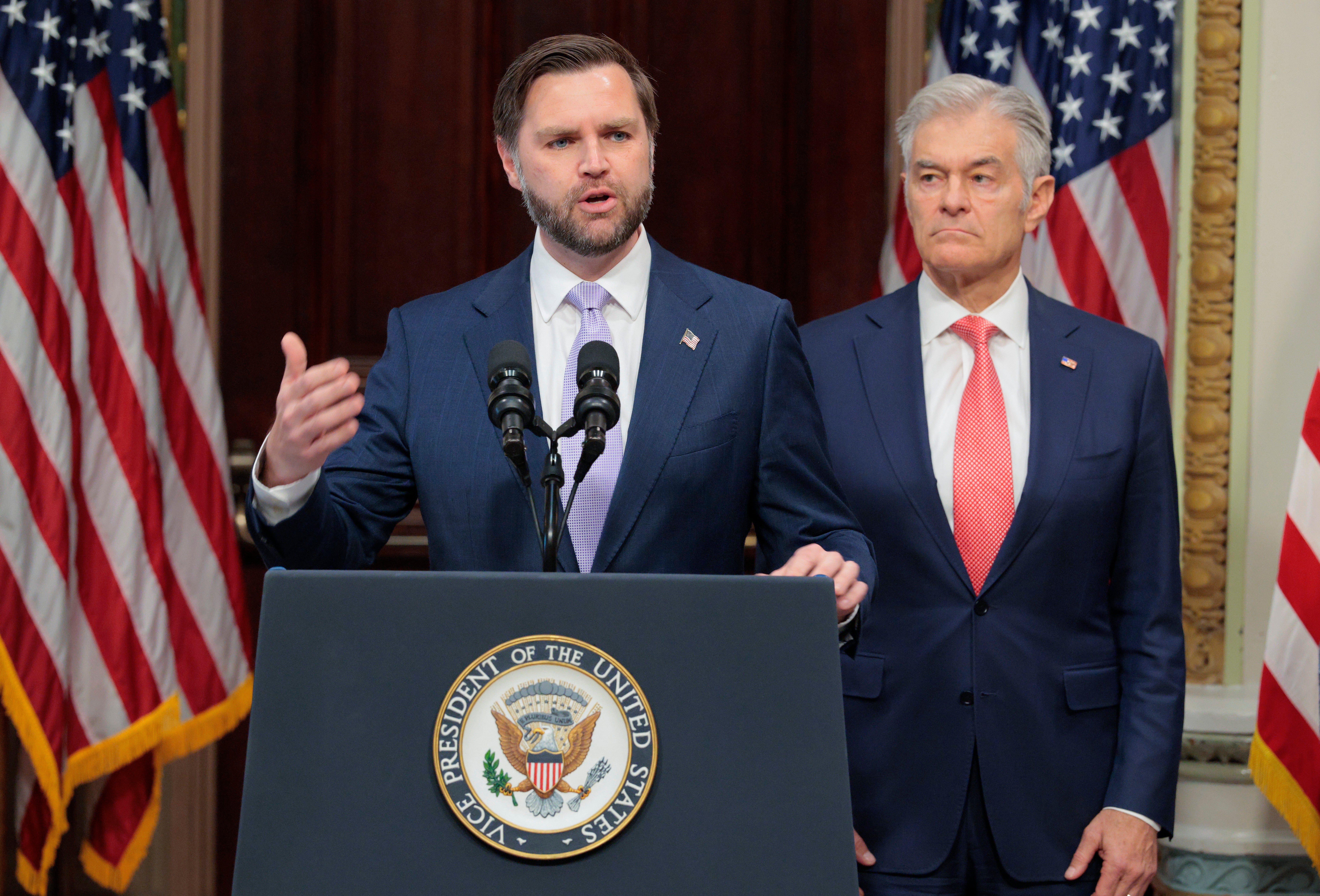 To menn taler på et podium med presidentens segl, sannsynligvis under en pressekonferanse. Amerikanske flagg er synlige i bakgrunnen