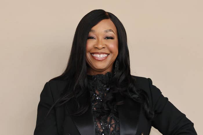 Shonda Rhimes smiling, wearing a black suit with a sequined lace top