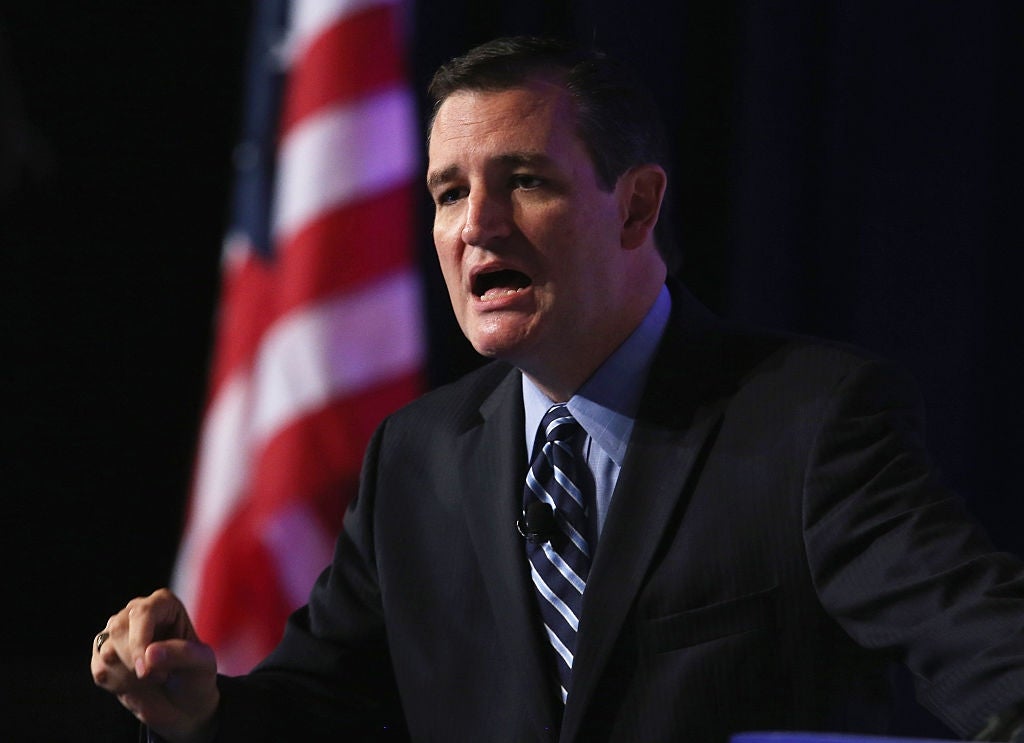 Ted Cruz i dress og slips snakker lidenskapelig, gestikulerer med én hånd, med delvis utsikt over et flagg i bakgrunnen
