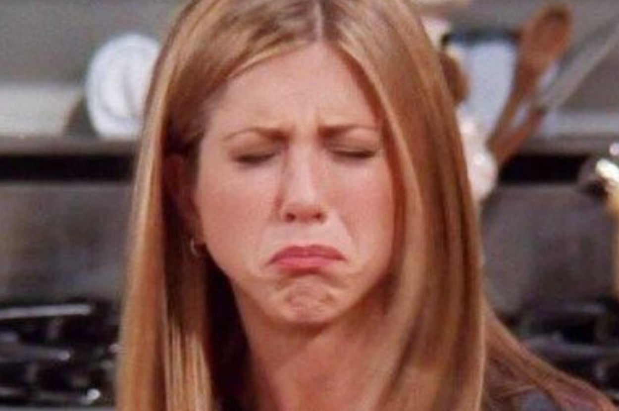 A person making a humorous pout face, with long straight hair, appears to be indoors