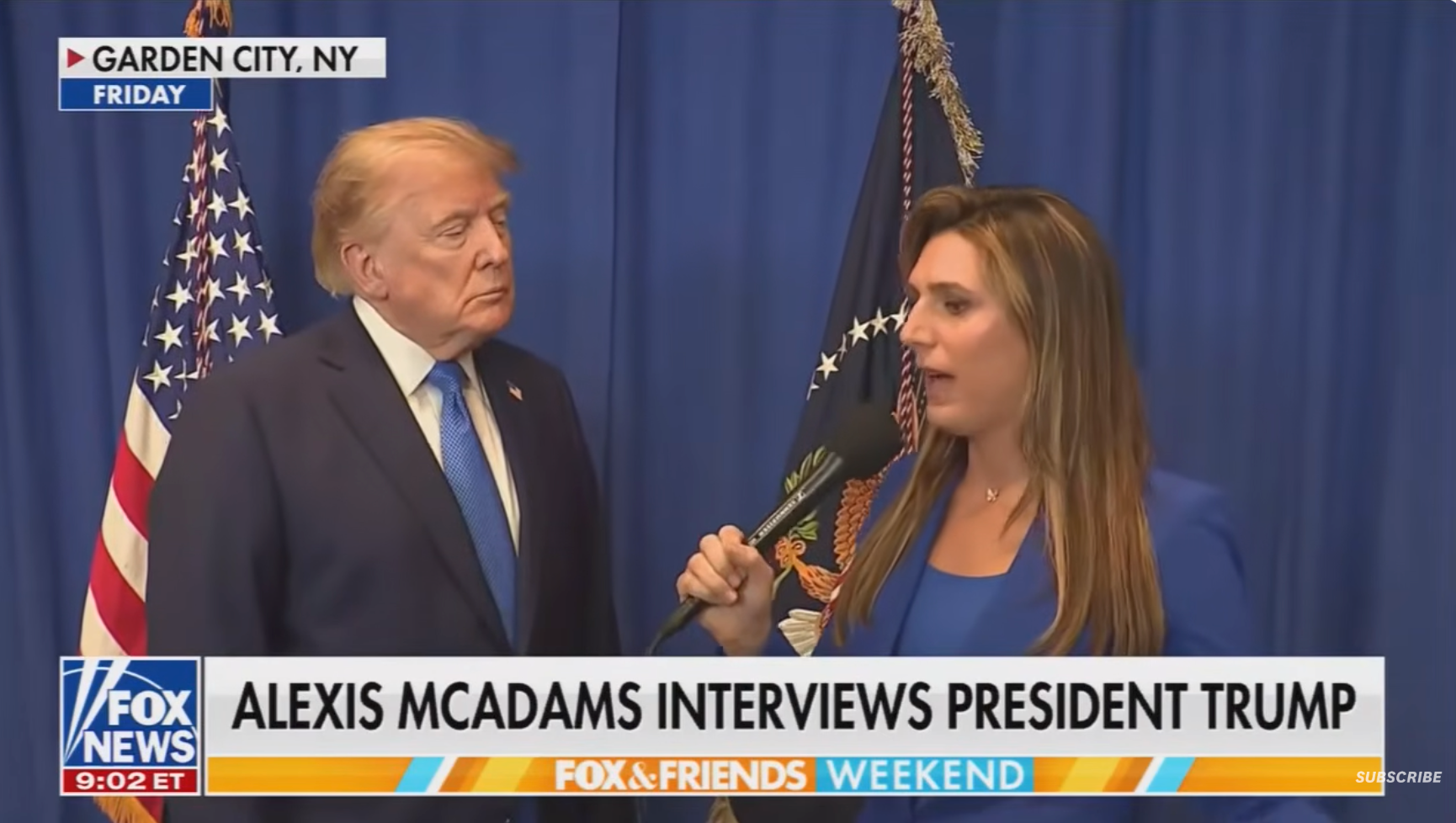 En journalist i blått intervjuer en mann i dress ved siden av amerikanske flagg. Fox News banner lyder: