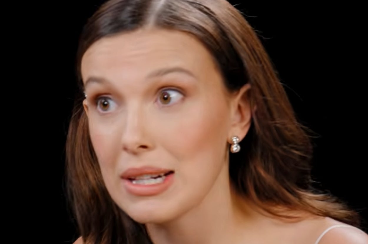 Person with long hair and pearl earrings speaking, likely discussing work or financial topics
