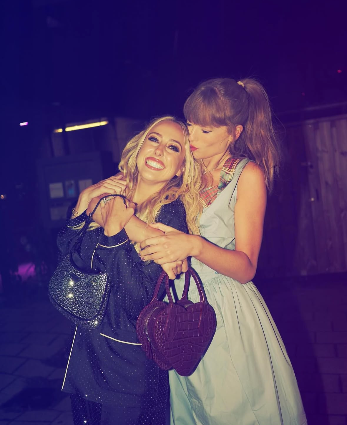 Brittany Mahomes and Taylor Swift pose in warm embrace.