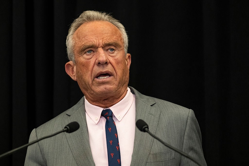Robert F. Kennedy Jr. i dress og slips taler ved et podium under en formell begivenhet
