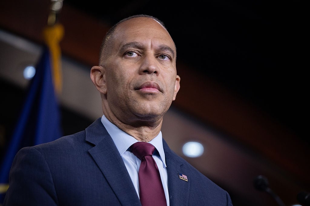 Hakeem Jeffries, i dress og slips, står i en profesjonell setting