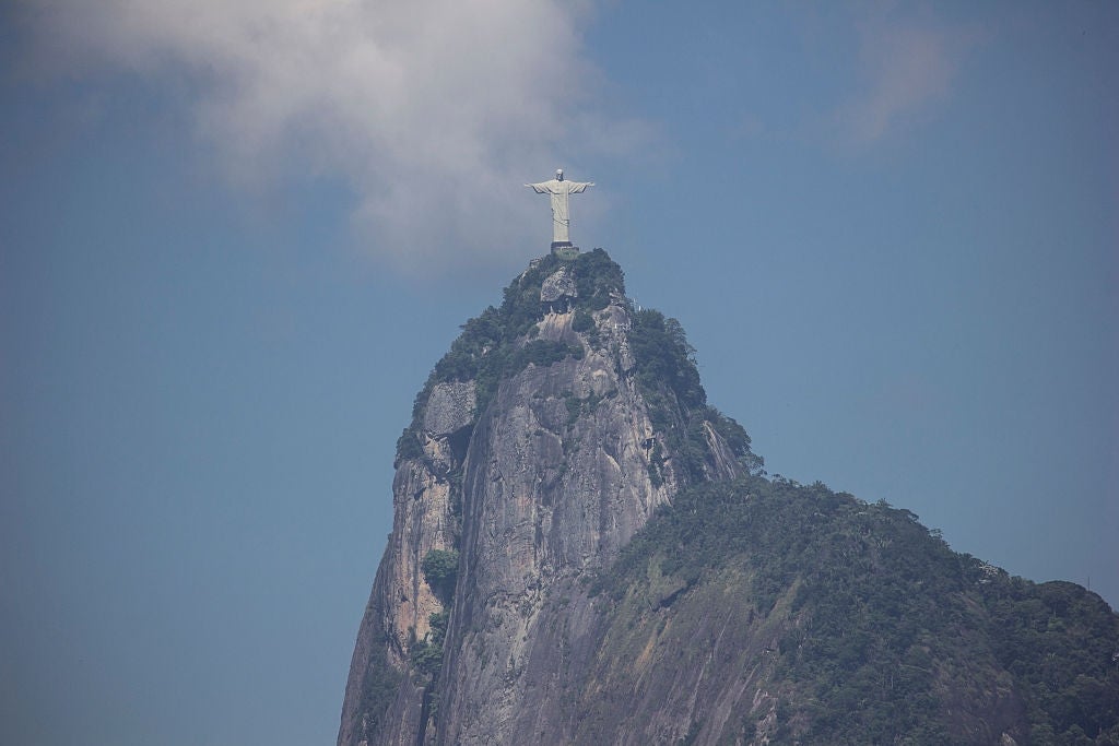 Christ the Redeemer statue atop Corcovado Mountain, surrounded by clouds, overlooking Rio de Janeiro
