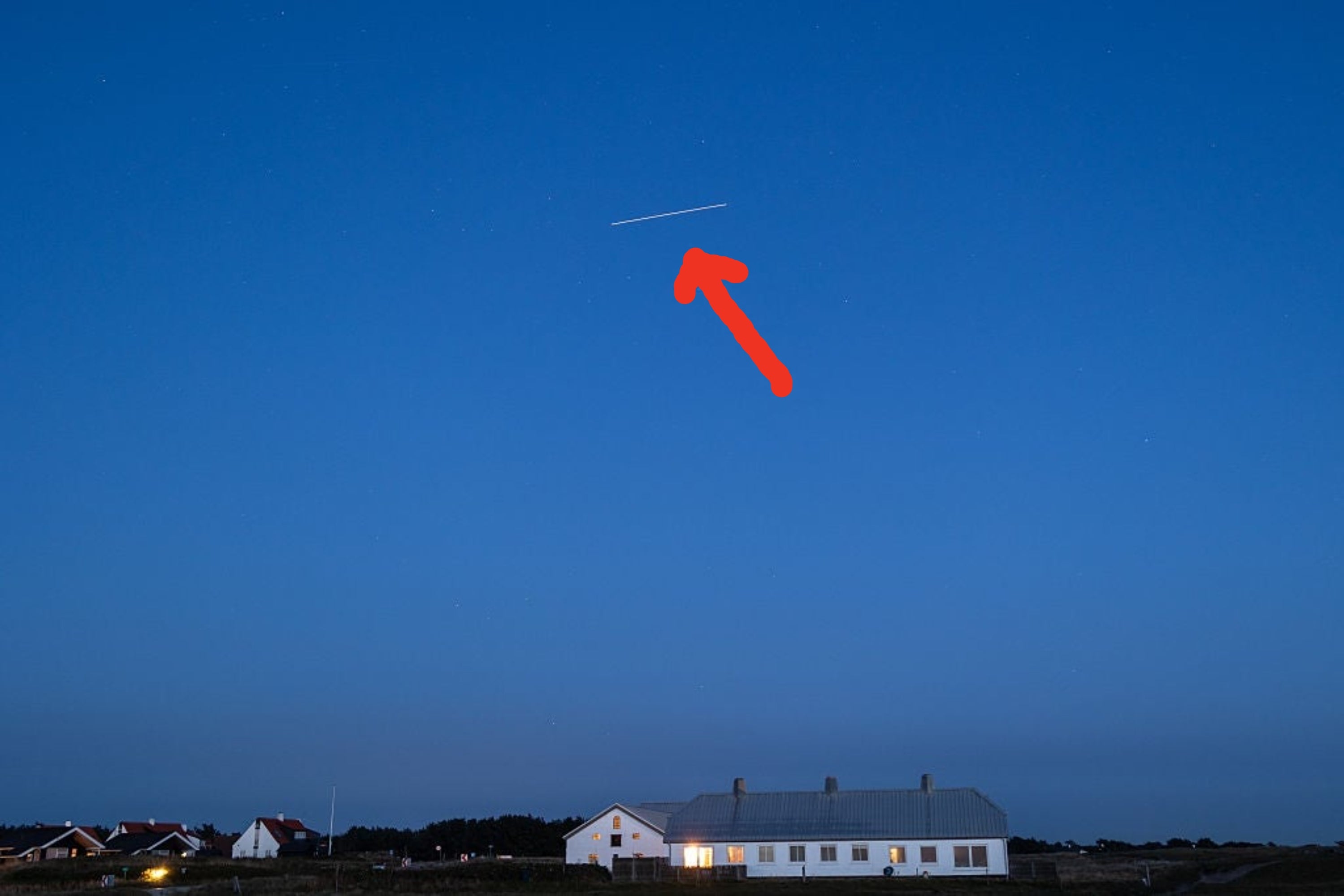 The International Space Station (ISS), reflecting light from the Sun, appears to streak across the sky