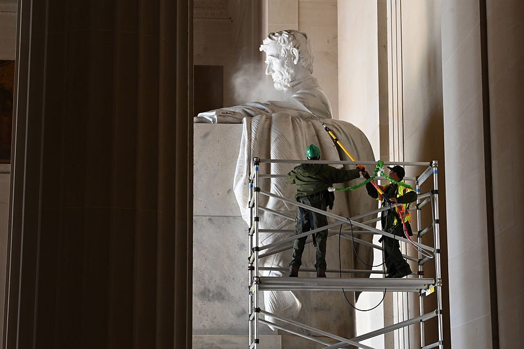Workers clean the statue of Abraham Lincoln at the Lincoln Memorial. They're using high-pressure hoses atop scaffolding