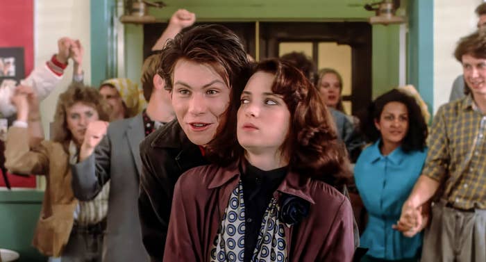 A scene from a movie with Christian Slater hugging Winona Ryder from behind