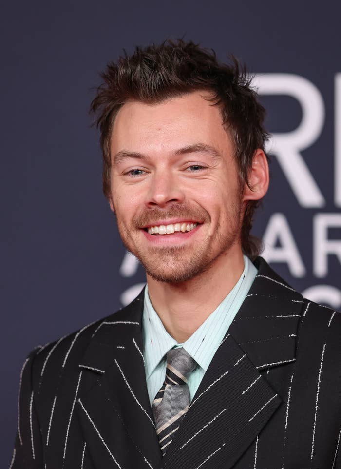 Person in pinstripe suit, smiling at a formal event