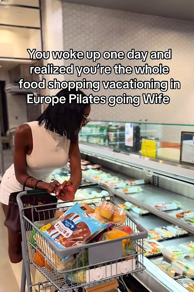 Woman in white top shopping with cart full of groceries. Text reads about realizing being a 'whole food shopping, vacationing in Europe, Pilates going wife.'