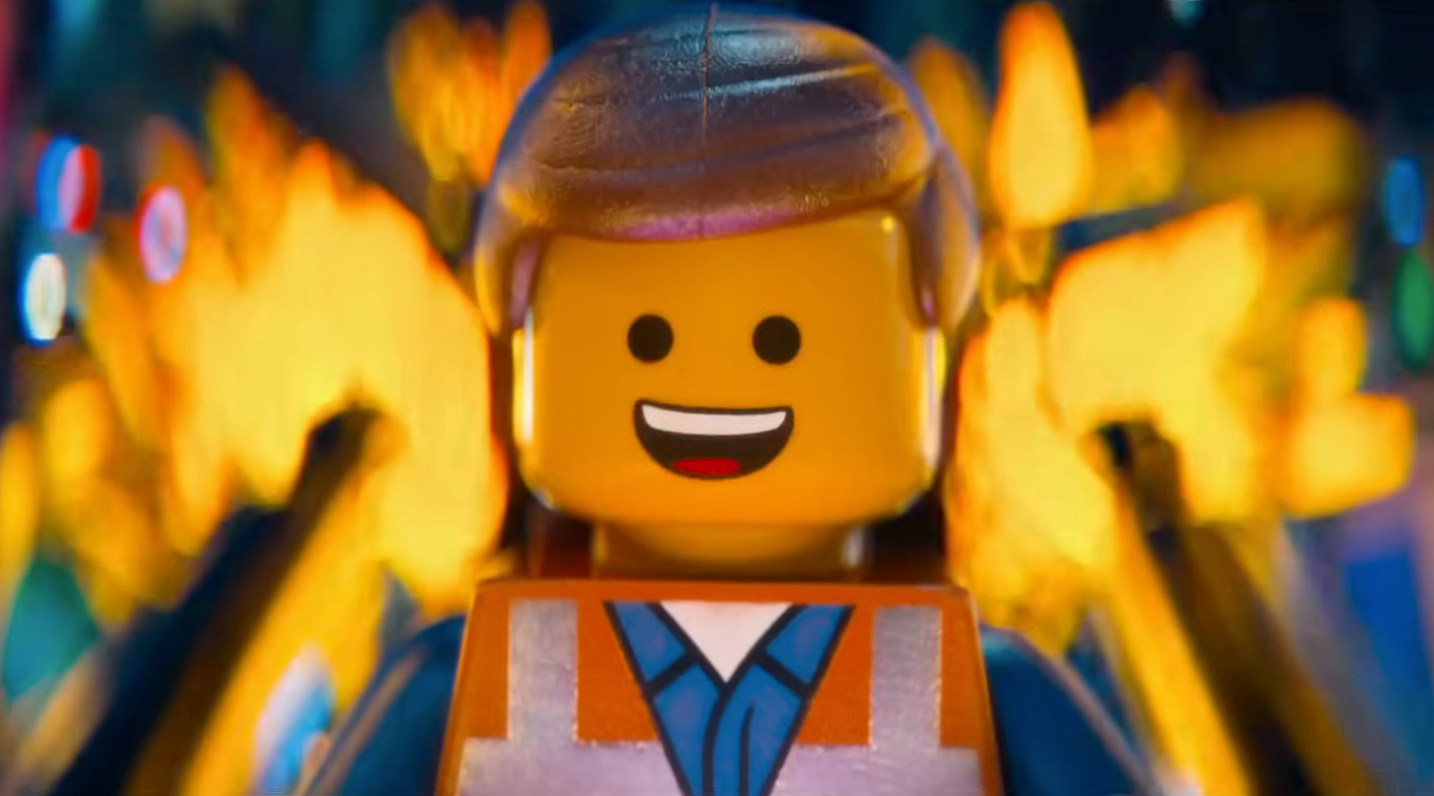 Smiling LEGO figure wearing a construction outfit with flames in the background, suggesting an action-packed scene