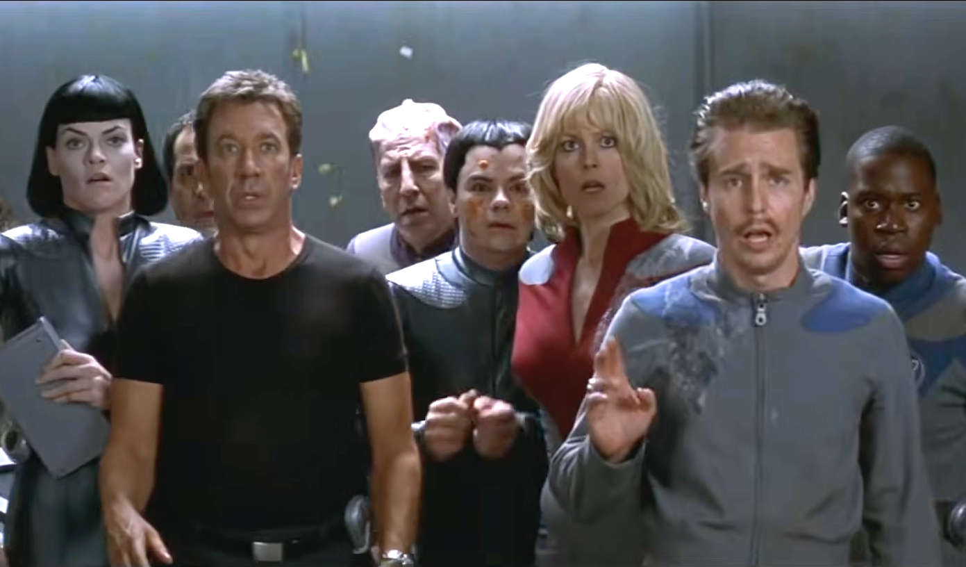 Actors in sci-fi costumes look surprised, with intense expressions, in a movie scene set on a spaceship