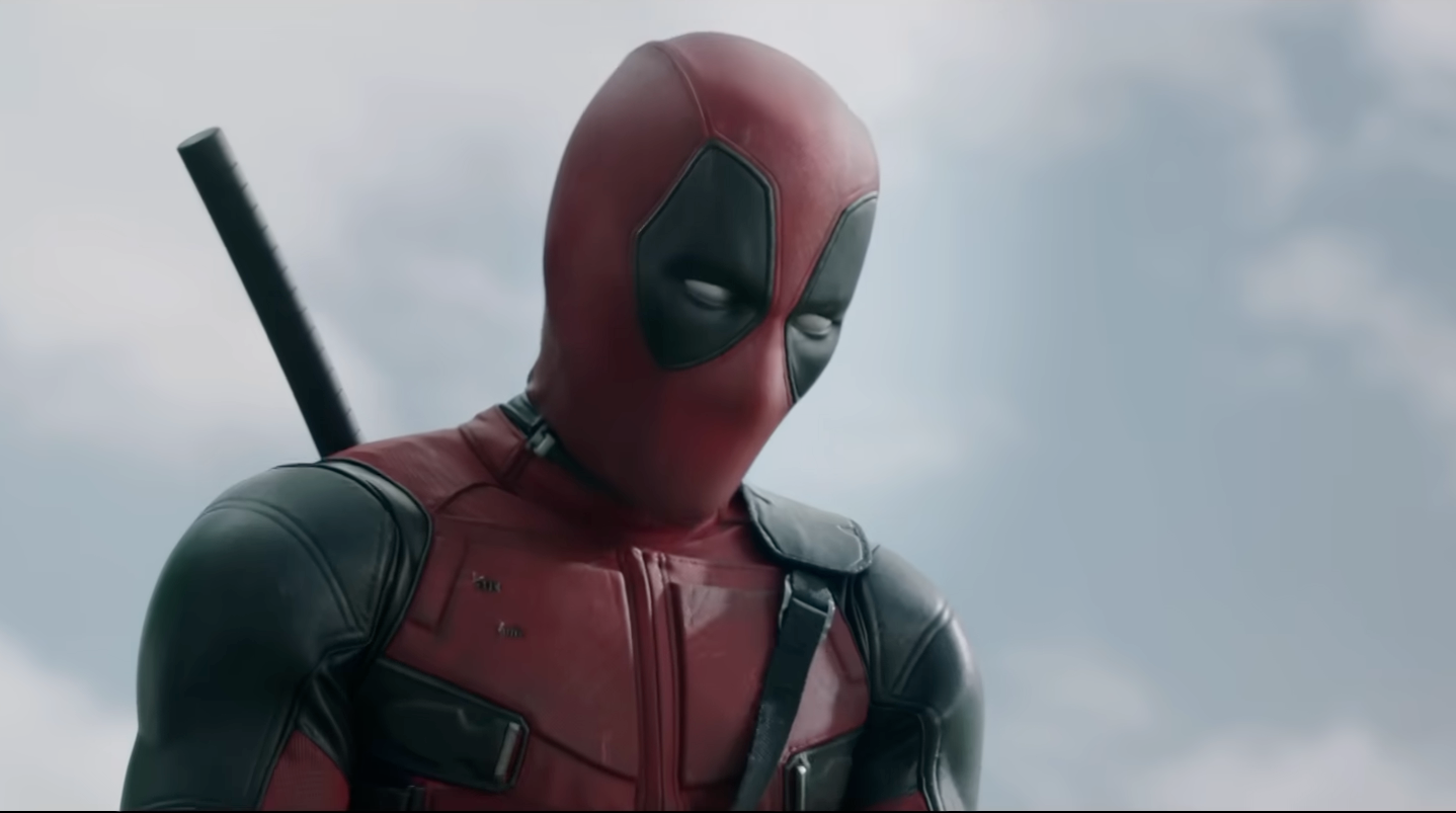 Character in red and black suit with a mask, equipped with weapons, appears contemplative against a cloudy sky