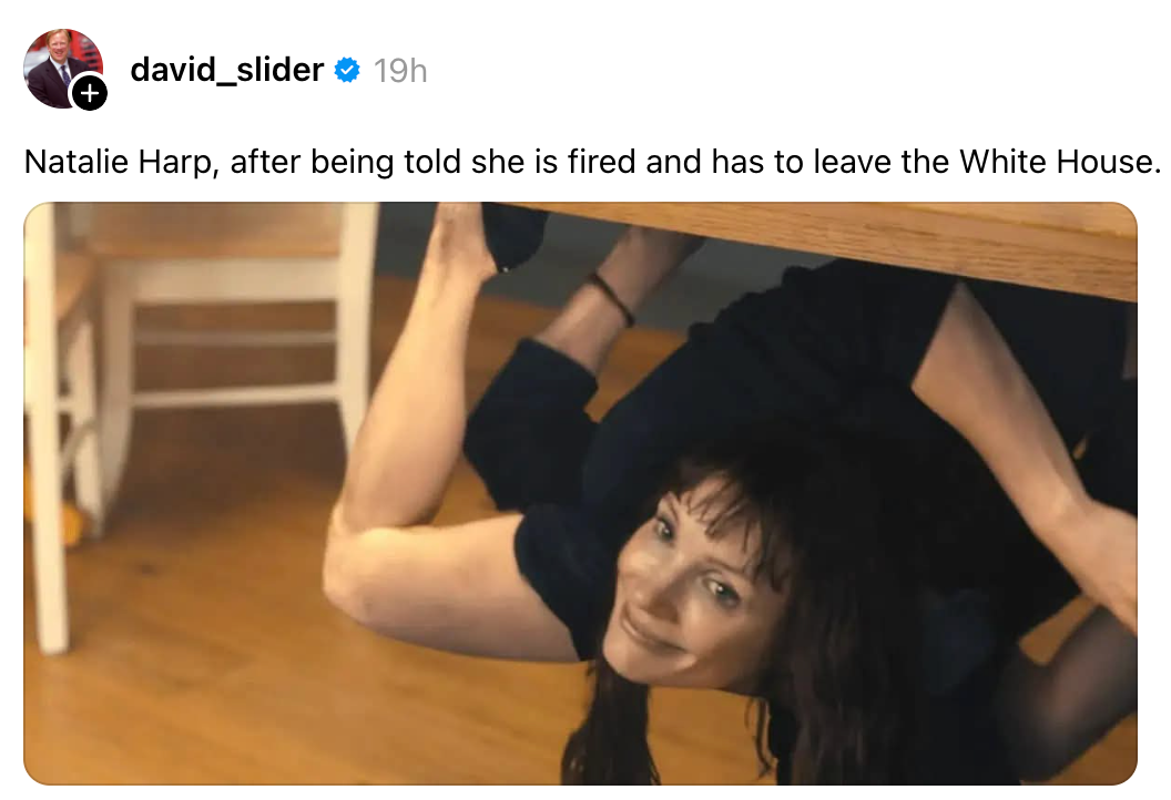 En person huker seg humoristisk under et bord og smiler til kameraet