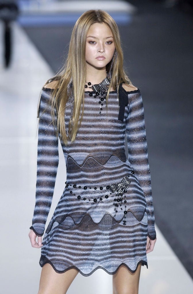 striped dress with wavy patterns and embellishments, walking on a runway