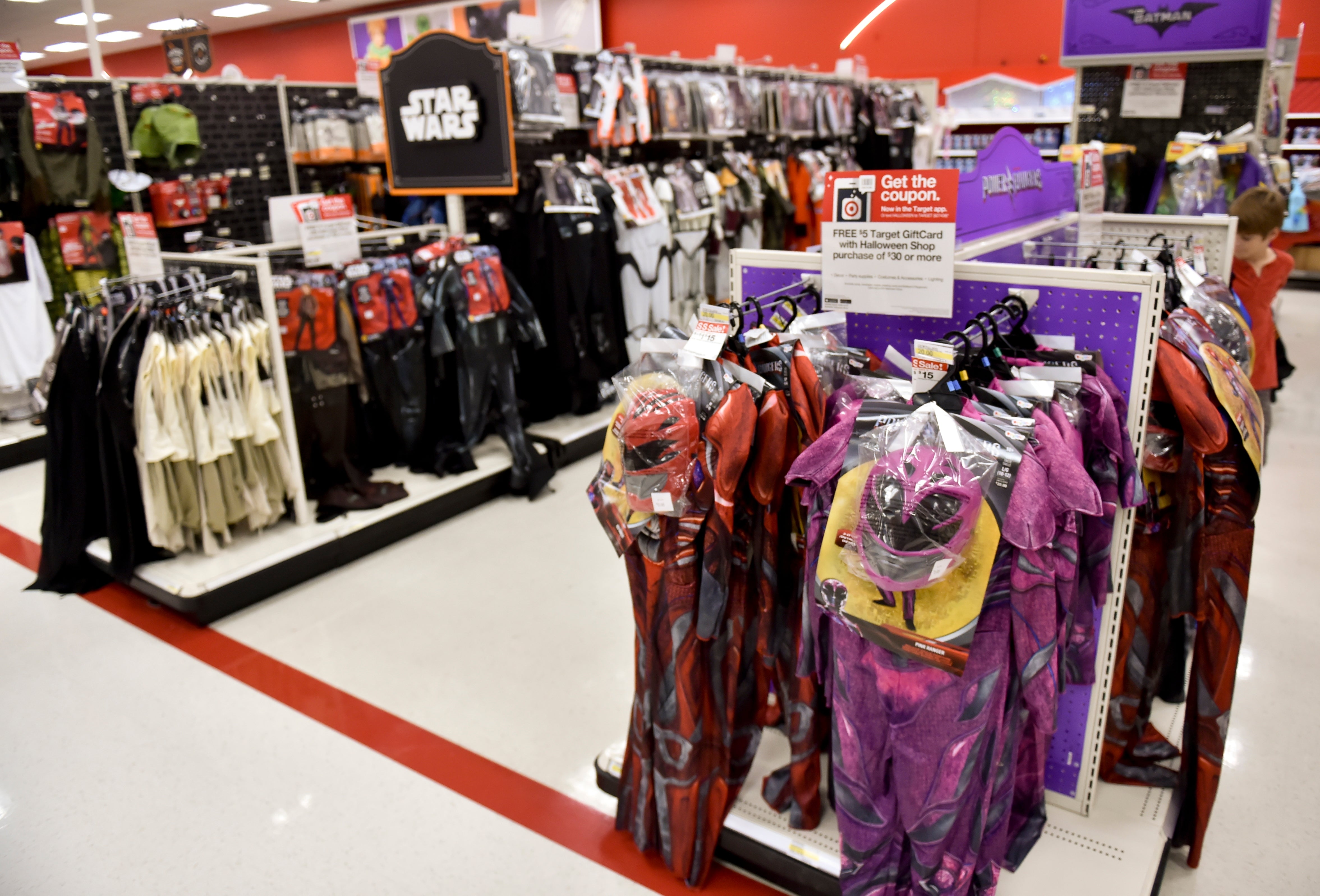 Butikkgang med Star Wars- og Power Rangers-kostymer vist på stativer, med forskjellige karakterantrekk for Halloween-kjøpere