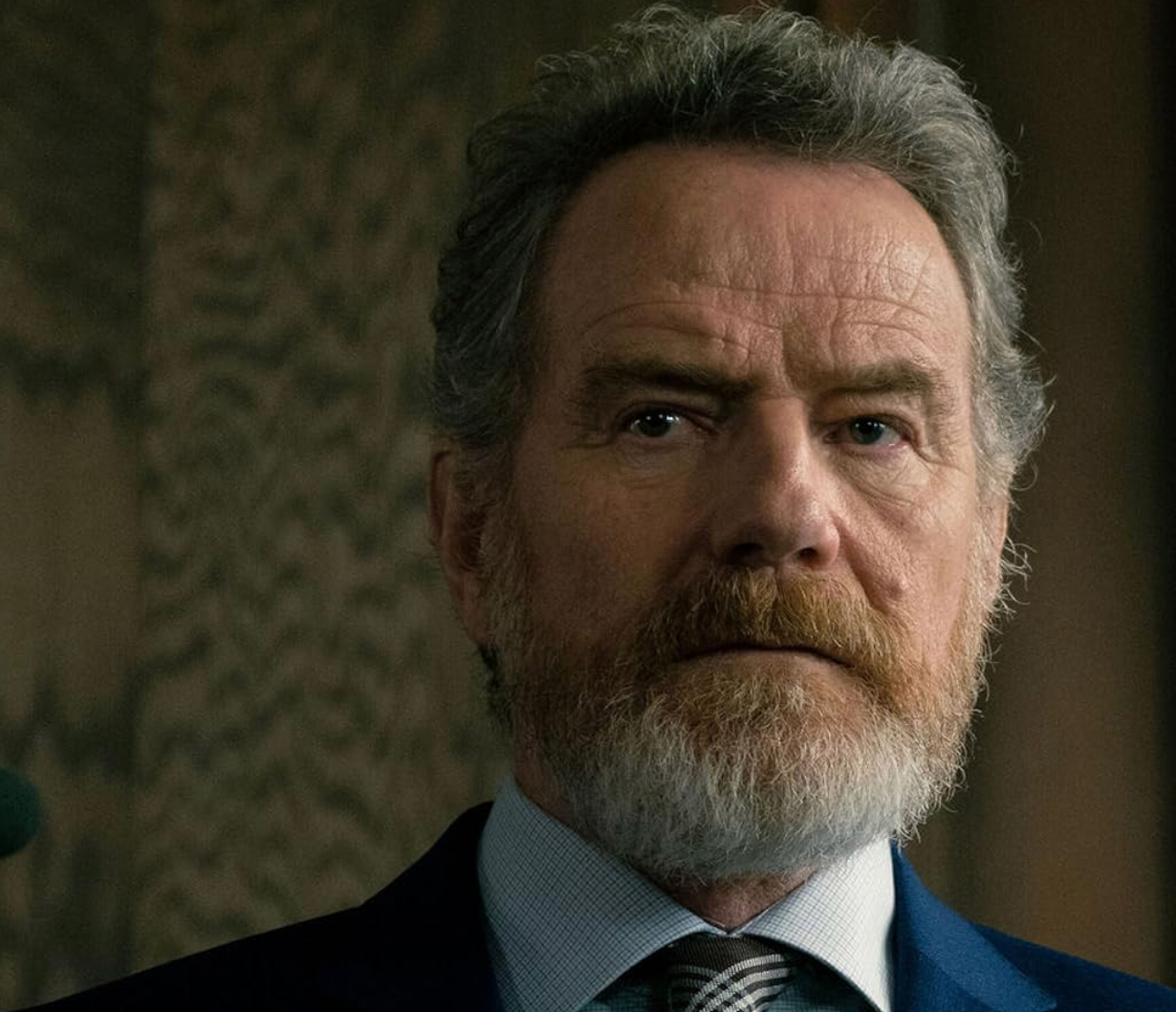 A bearded man in a suit and tie looks intently ahead, suggesting a serious or contemplative moment