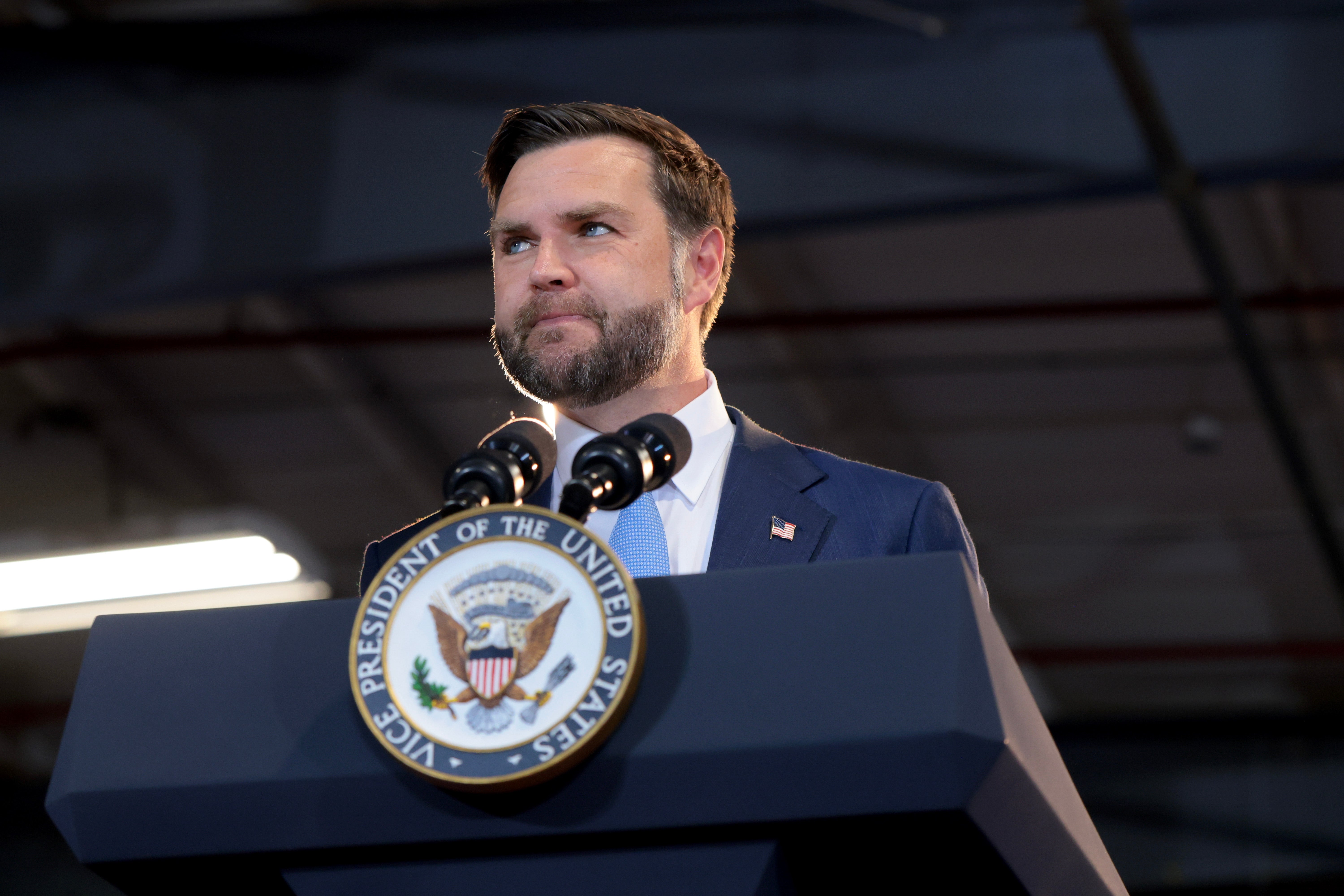 En person står på et podium med USAs visepresidents segl og holder en tale innendørs
