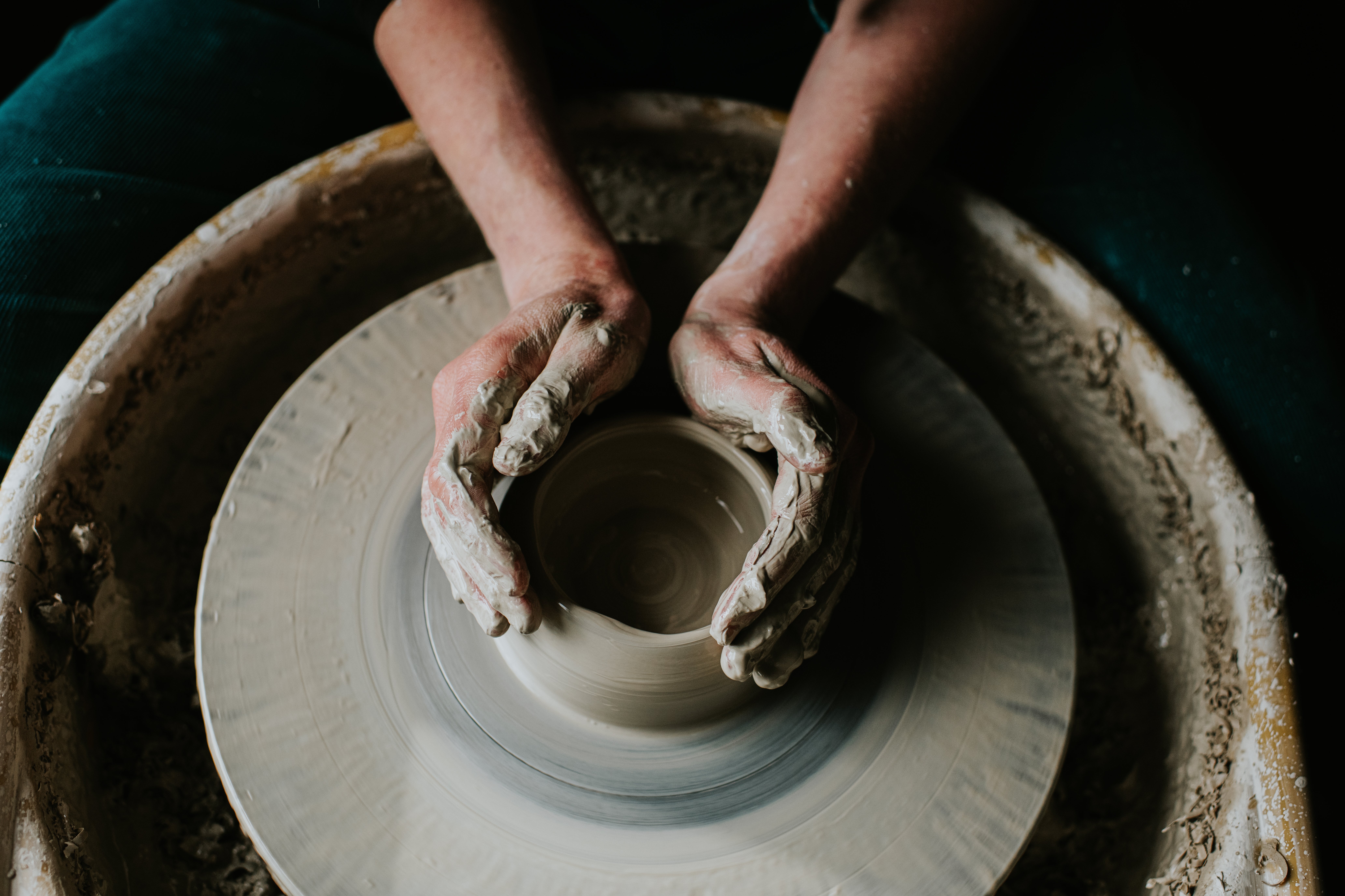 Hands shaping clay on a pottery wheel, symbolizing creativity and mindfulness in a health-focused article