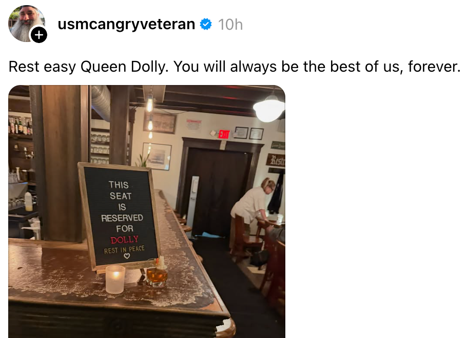 Sign on a bar counter: "This seat is reserved for Dolly. Rest in peace." Candle and flower beside the sign