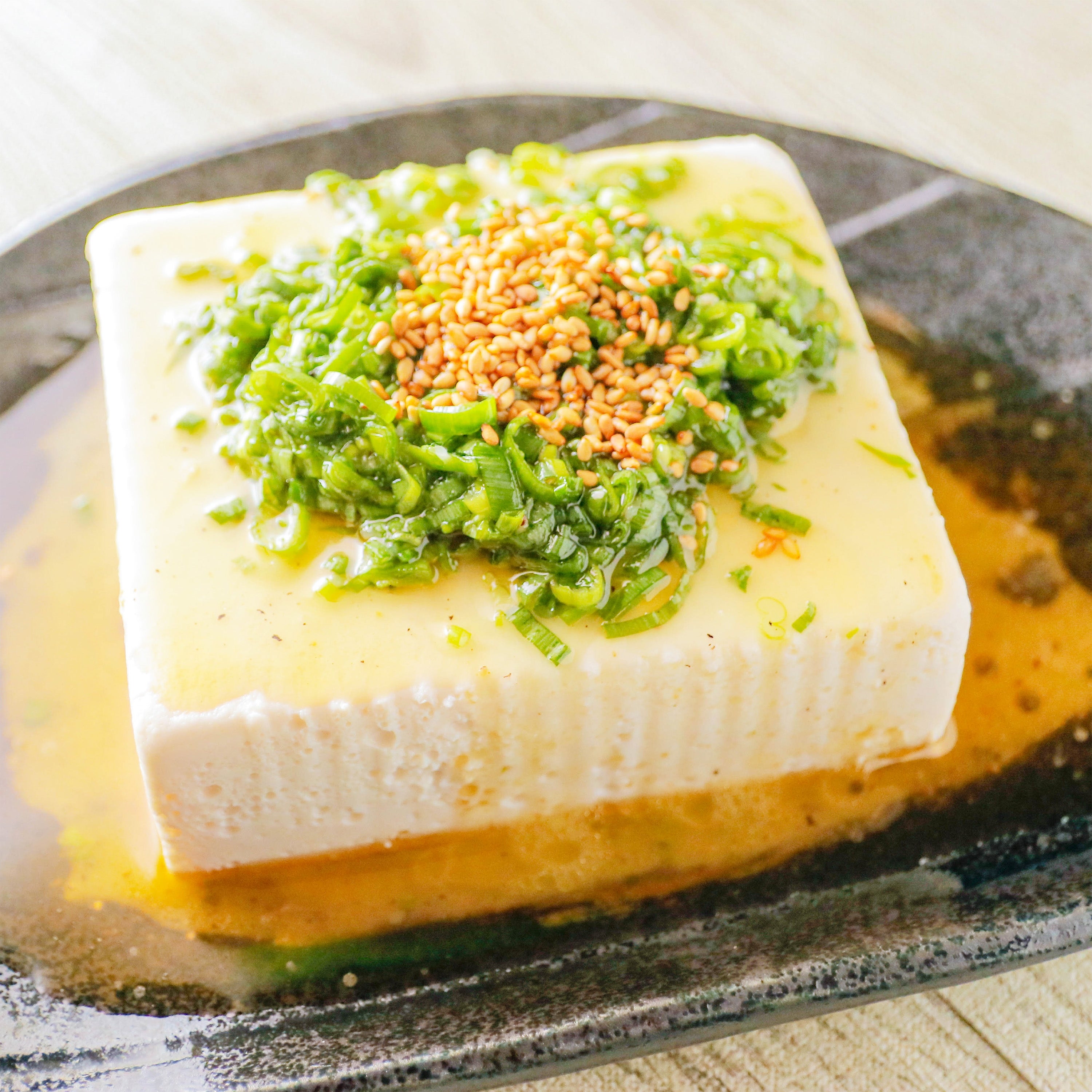 ねぎ塩だれと白いりごまをかけた冷奴。