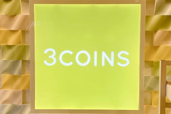 3COINSの看板が壁に飾られている。