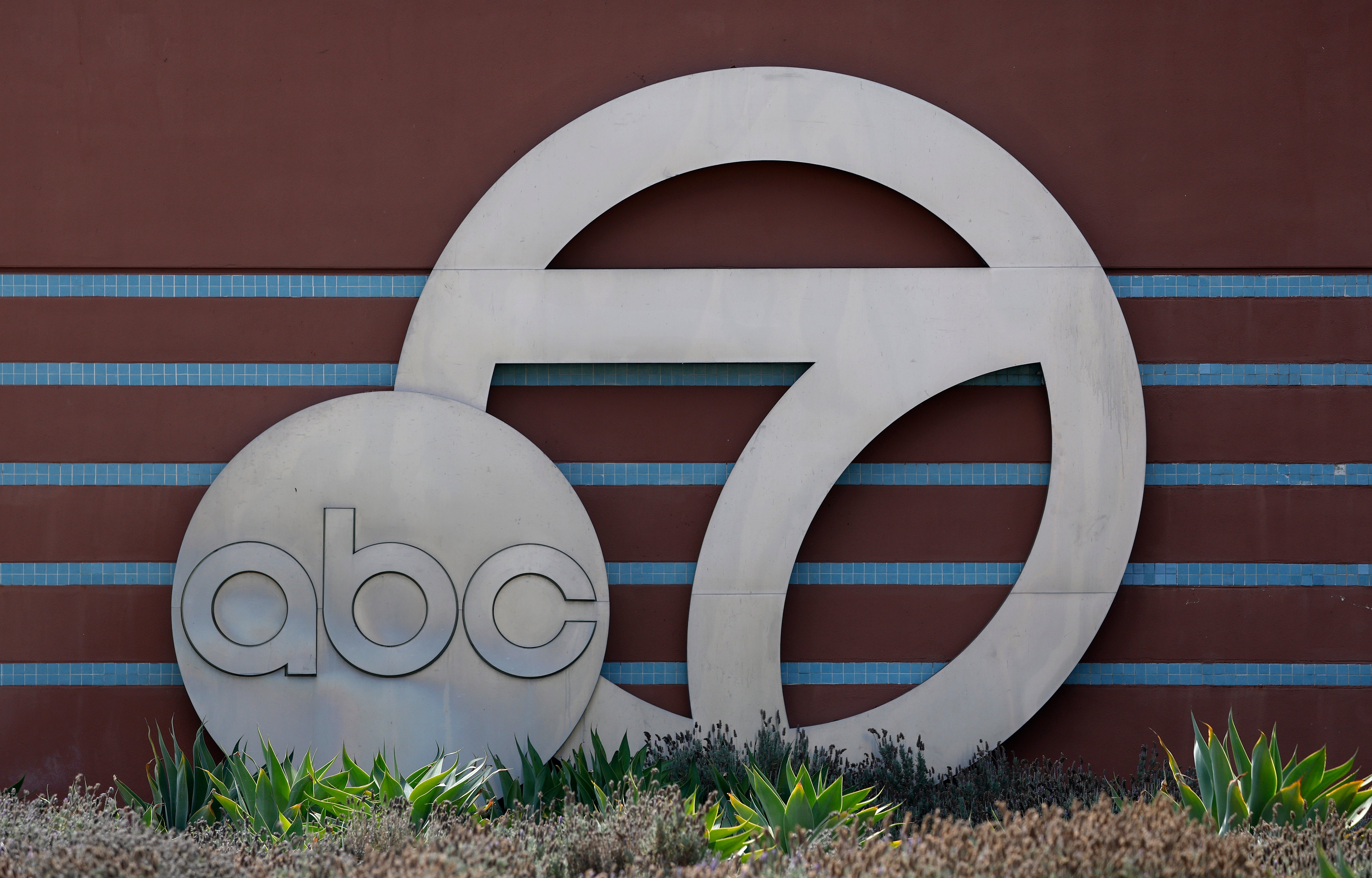 ABC 7-logo på utvendig bygning med planter foran