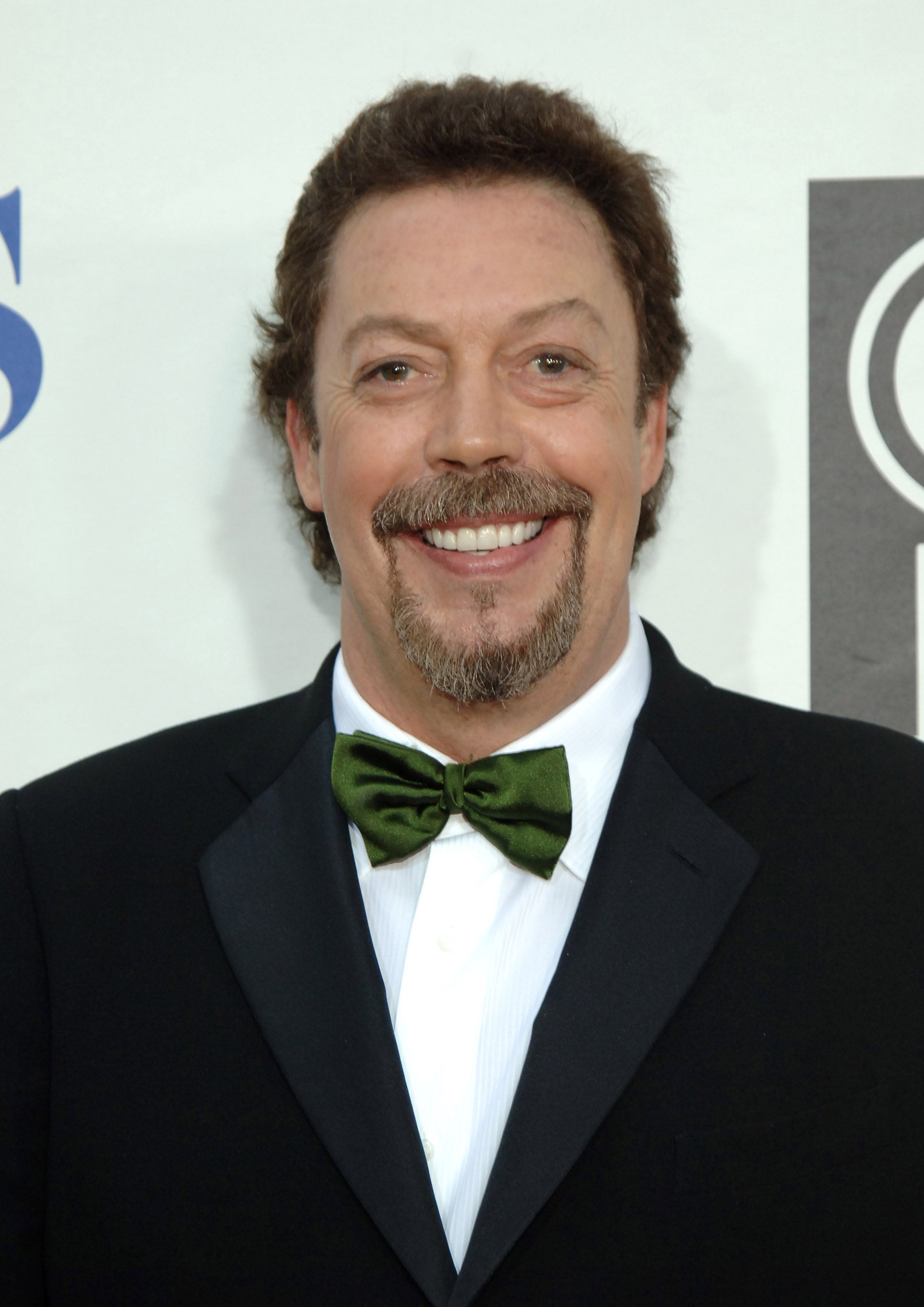 Person in a classic suit with a bow tie, smiling at an event