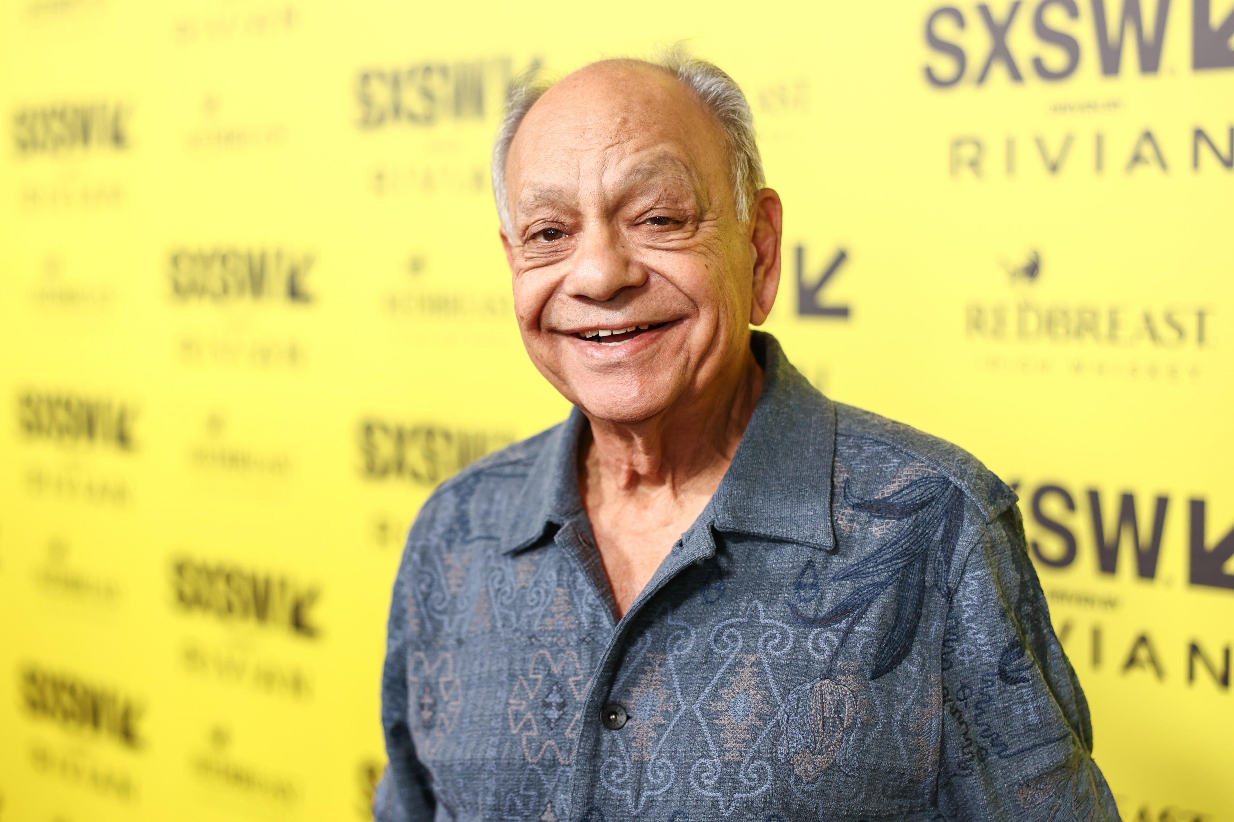 Person on the SXSW red carpet wearing a patterned button-up shirt, smiling