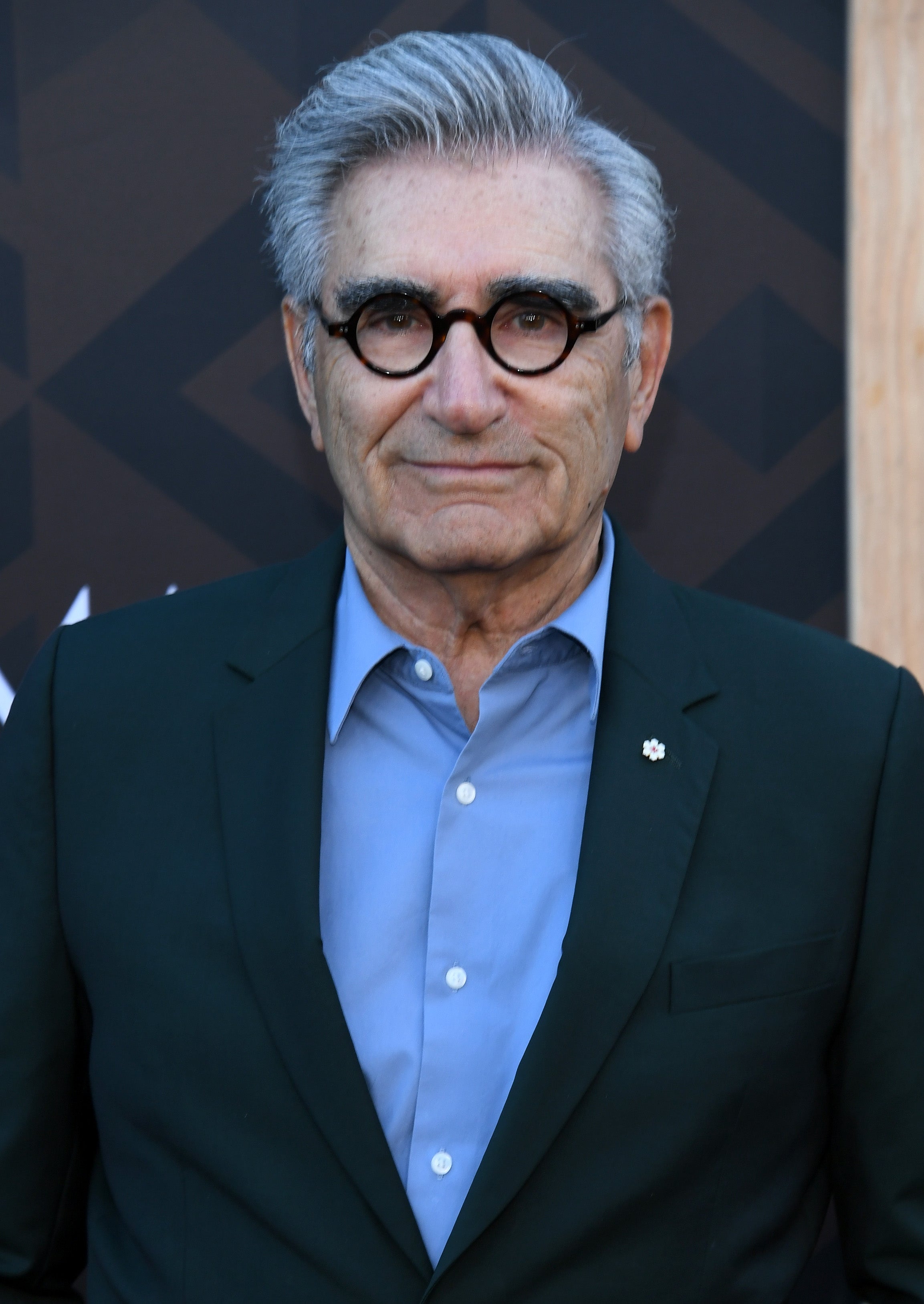 Person wearing a suit with a light shirt underneath, posing for a photo