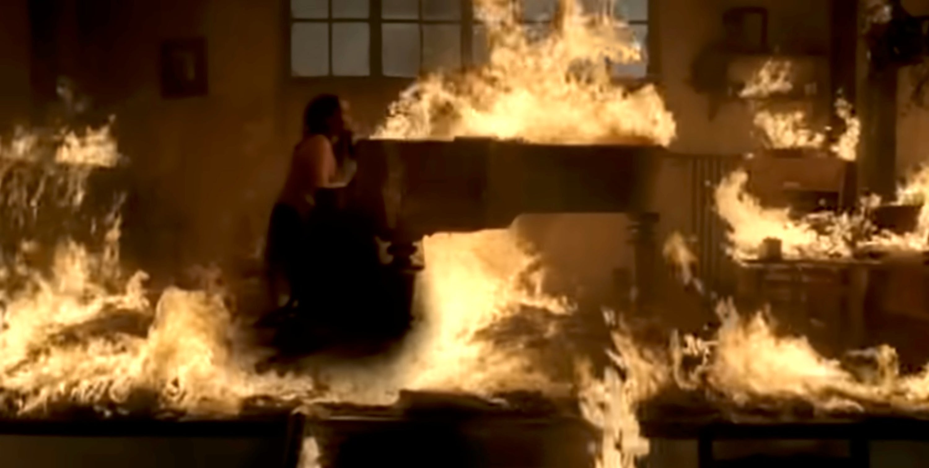 A grand piano engulfed in flames, with a person seated at it, creating a dramatic and intense musical performance