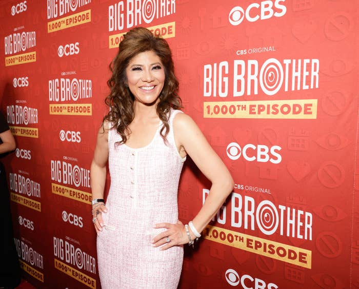 A person poses on a red carpet in a sleeveless, textured dress at an event for CBS's "Big Brother" 1000th episode celebration
