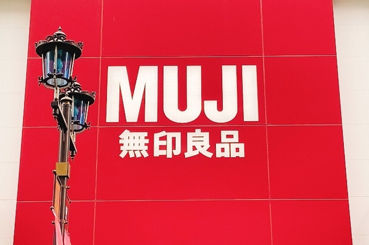 無印良品の店舗入り口。大きな看板に店名が書かれており、店舗の外観が見える。