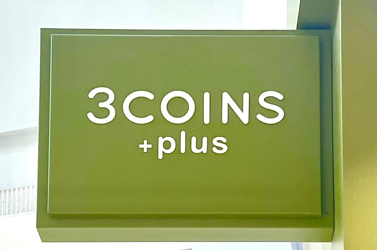 「3COINS +plus」と書かれた看板が店舗に掲げられている。